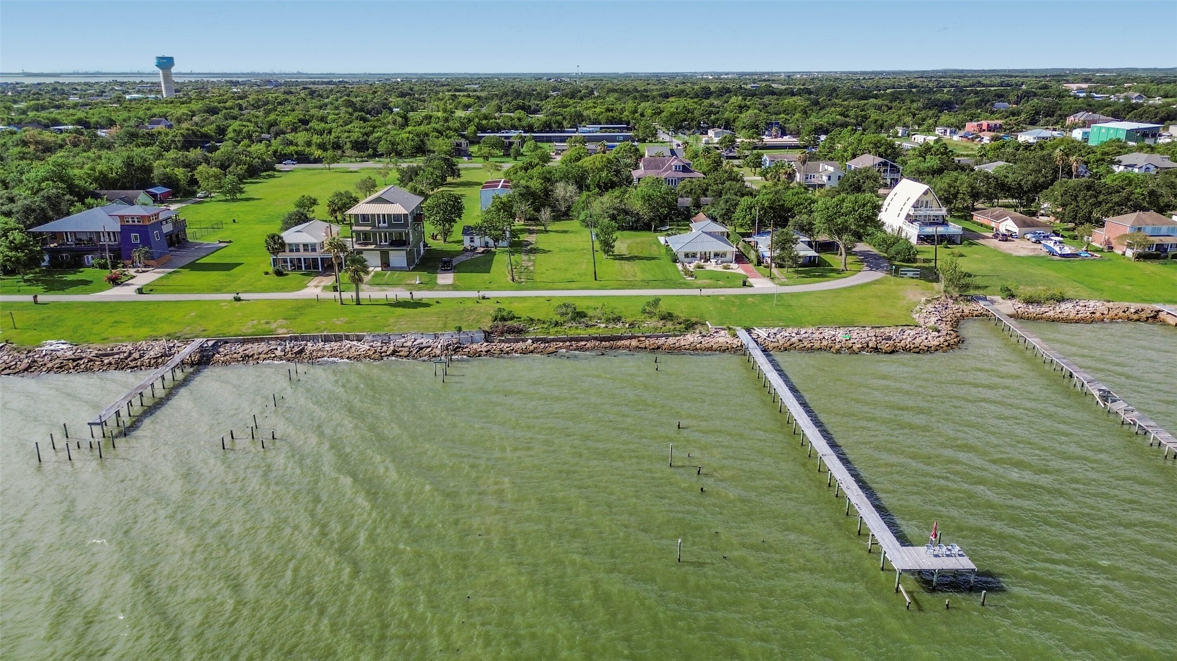 expansive green lawns, nestled along a serene shoreline with private docks extending into the tranquil waters.