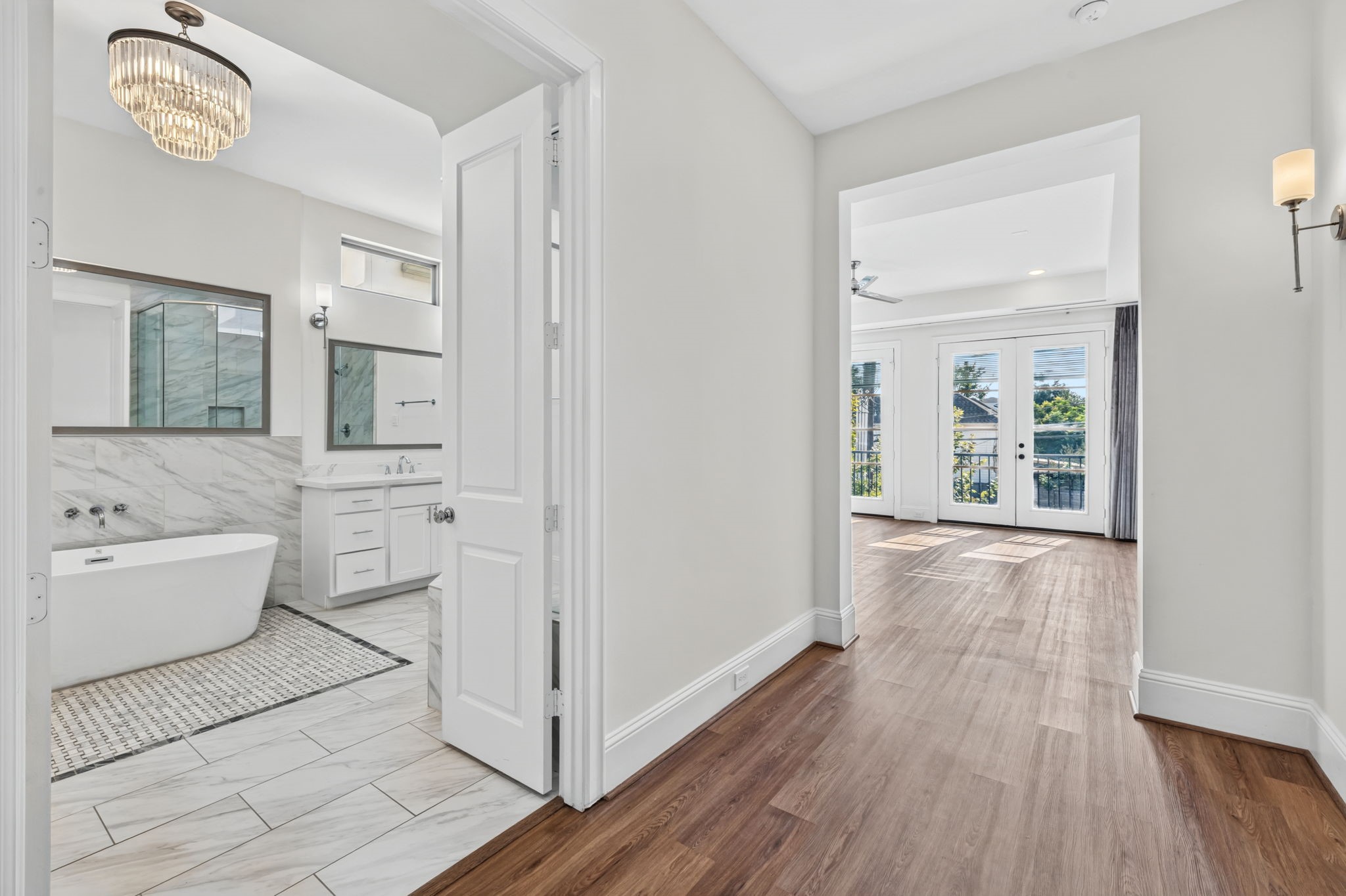 A private sanctuary: primary bedroom features a dedicated entry foyer leading to a grand ensuite bath with a large glass shower and separate soaking tub.