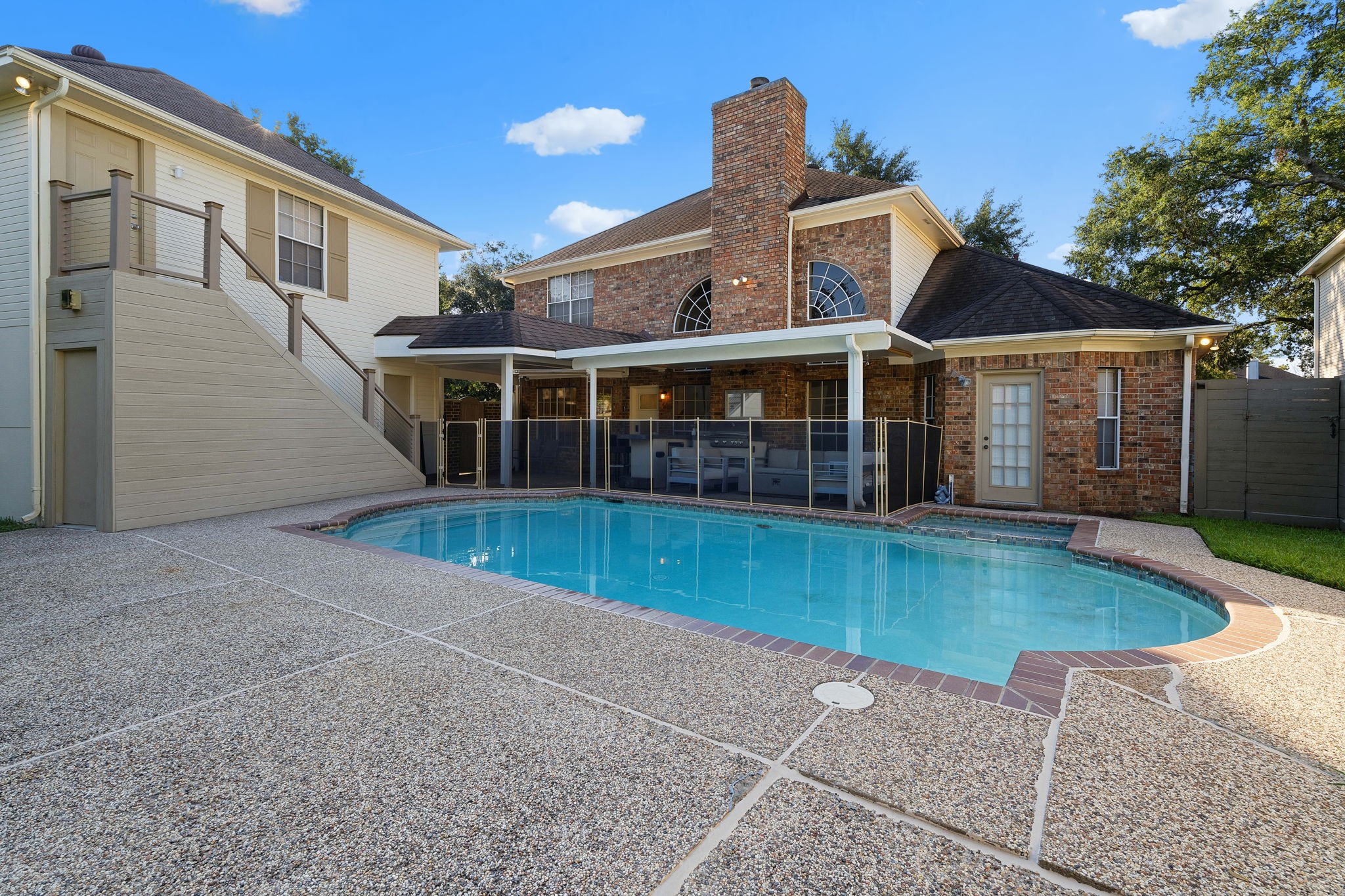 Backyard view showing the pool, home, and the stairs that lead to the private garage guest suite