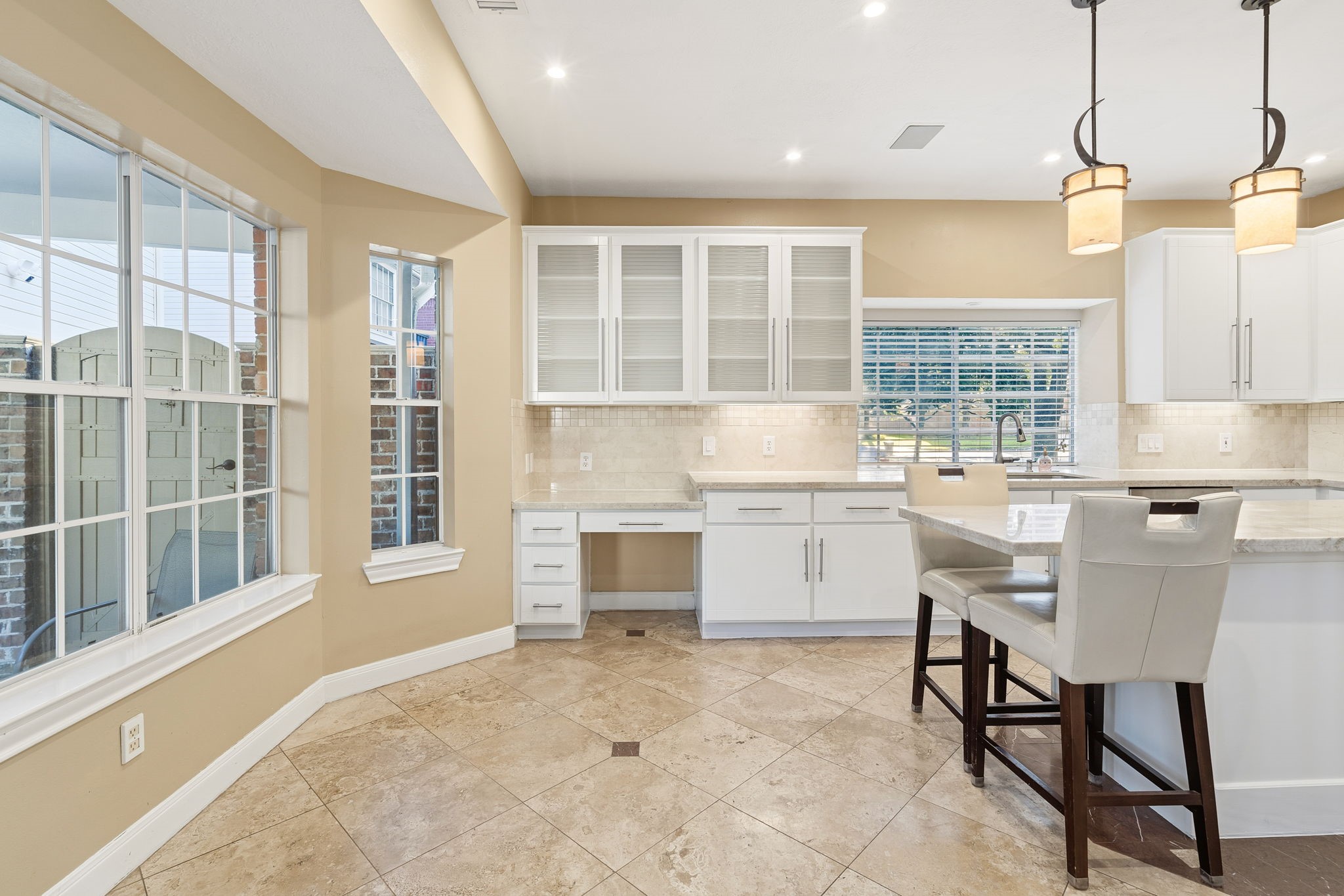 Kitchen nook overlooks the pool with tons of windows for natural lighting