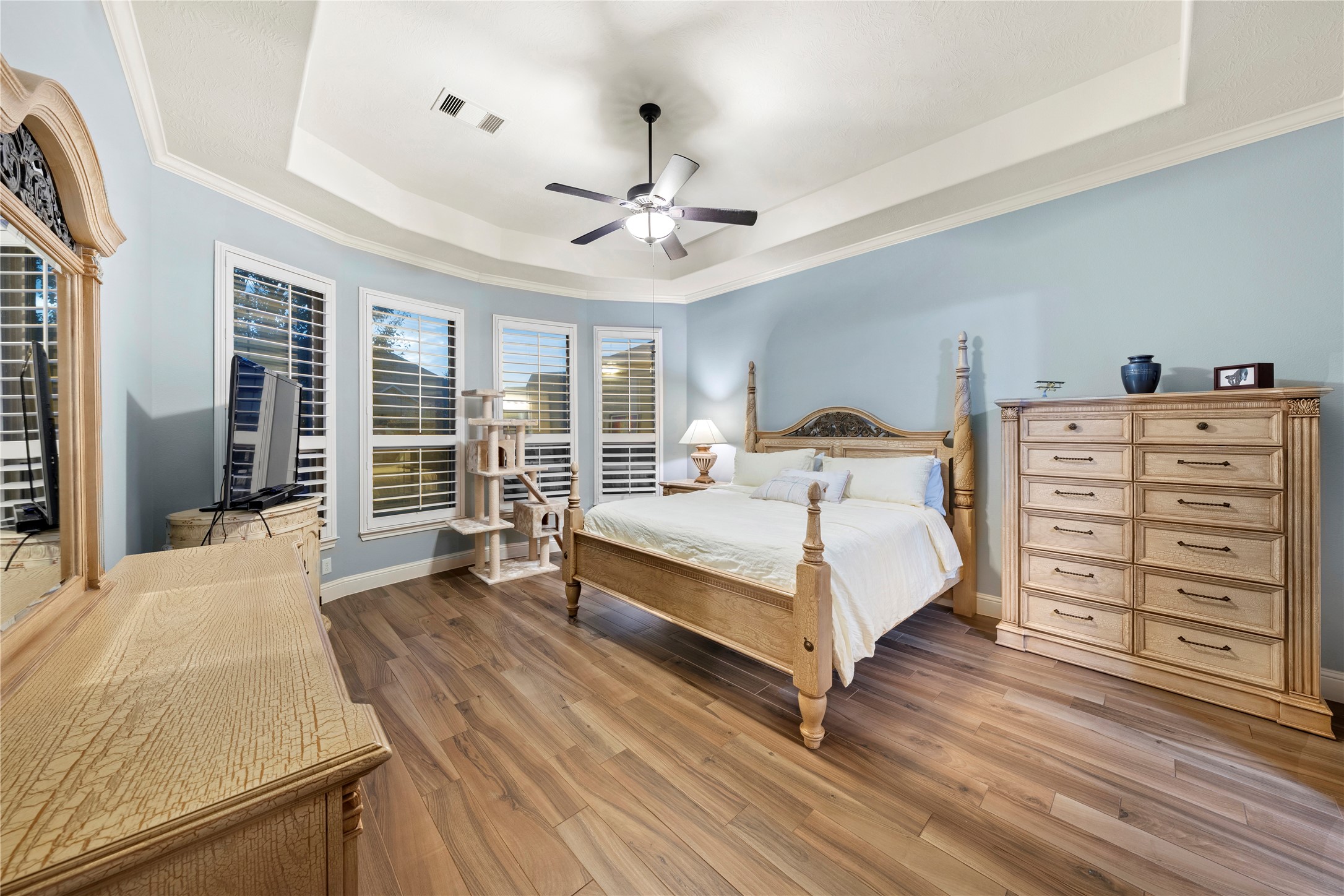 Here is your private oasis in the primary bedroom, featuring elegant Italian tile floors, abundant natural light, and a stylish coffered ceiling.