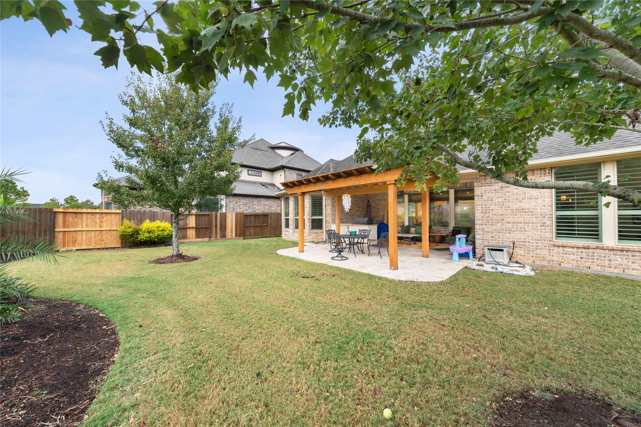 Discover the perfect outdoor oasis with a spacious covered porch, enhanced by a pergola and a fully equipped outdoor kitchen for seamless entertaining.