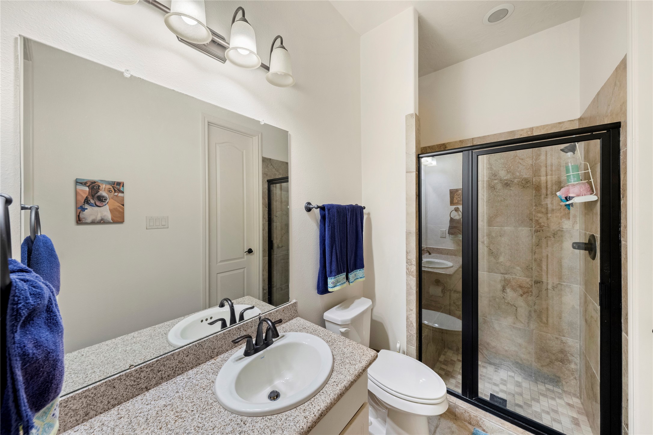 Experience the elegance of a full bath featuring a beautifully tiled, glass-enclosed shower, offering both style and functionality.