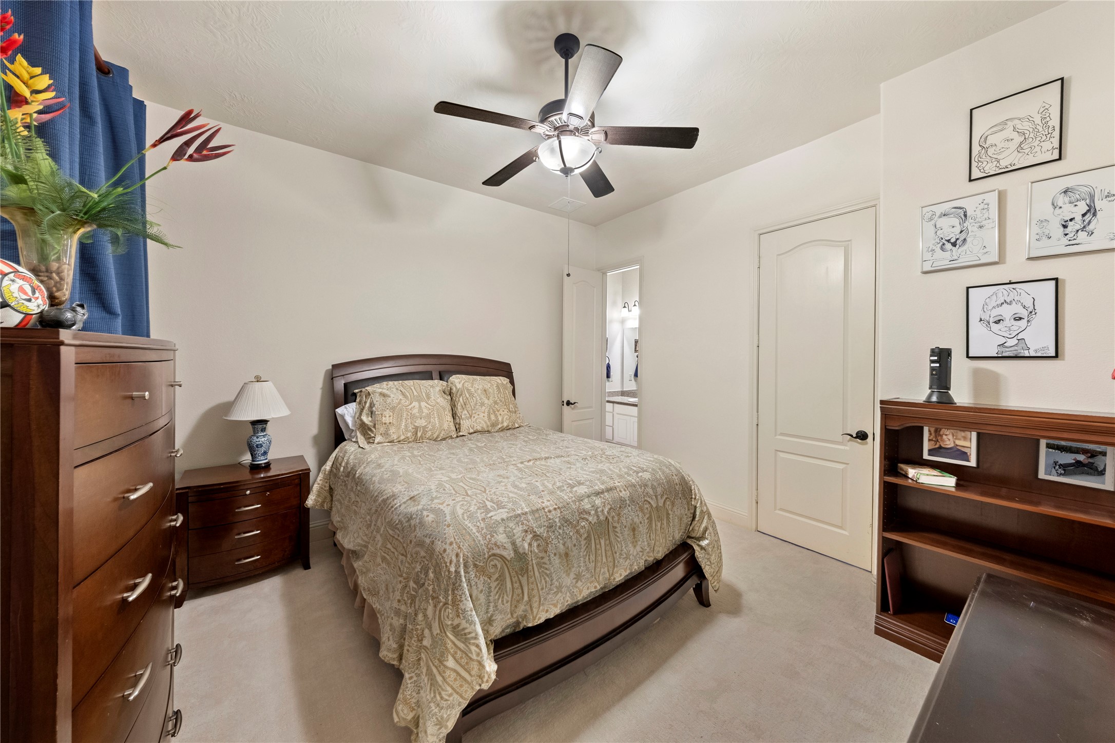 Cozy bedroom featuring a comfortable setting, complemented by a ceiling fan and ample natural light.