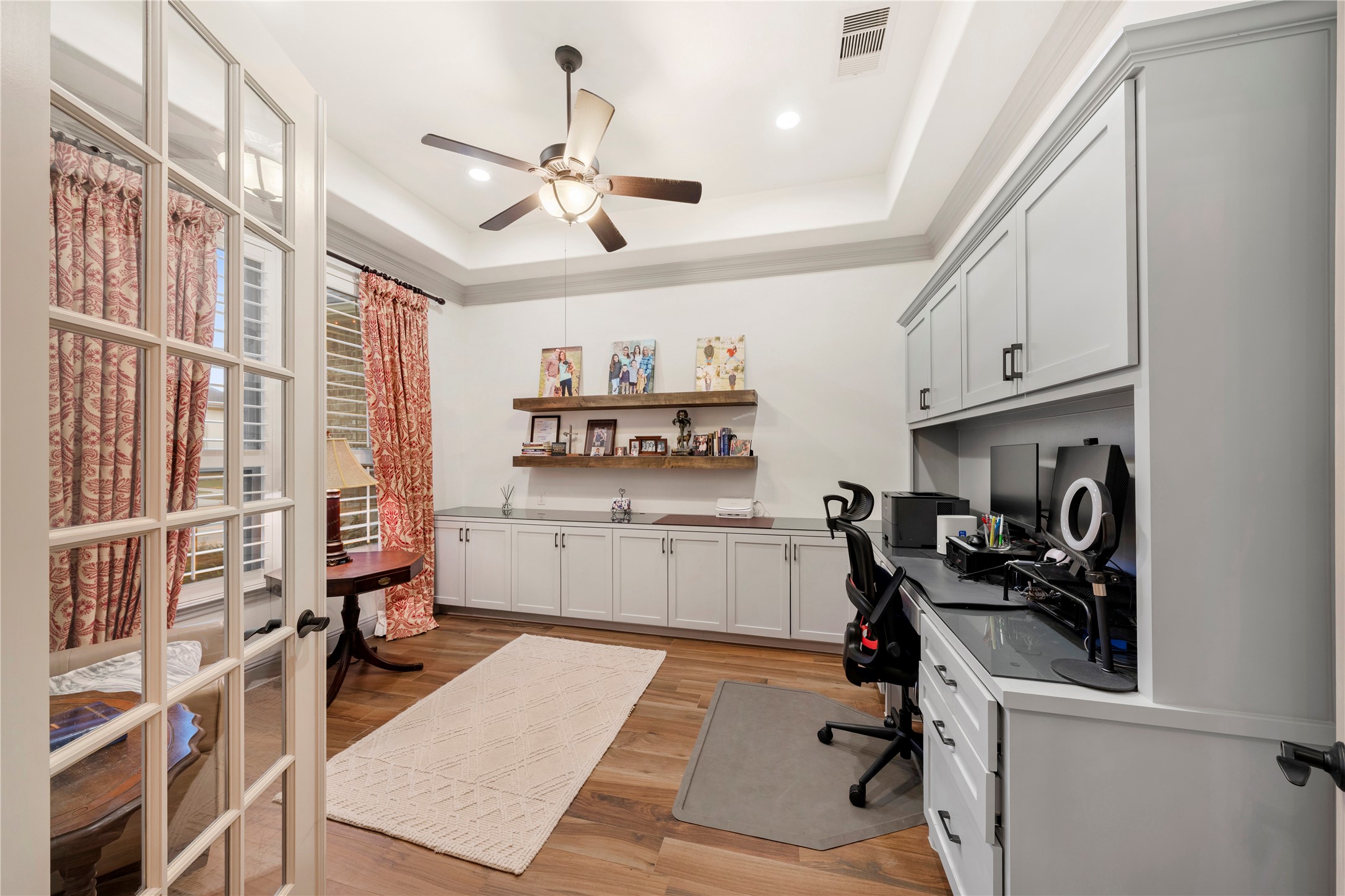 A spacious office greets you with elegant French doors and custom built-in cabinetry, offering both style and privacy.