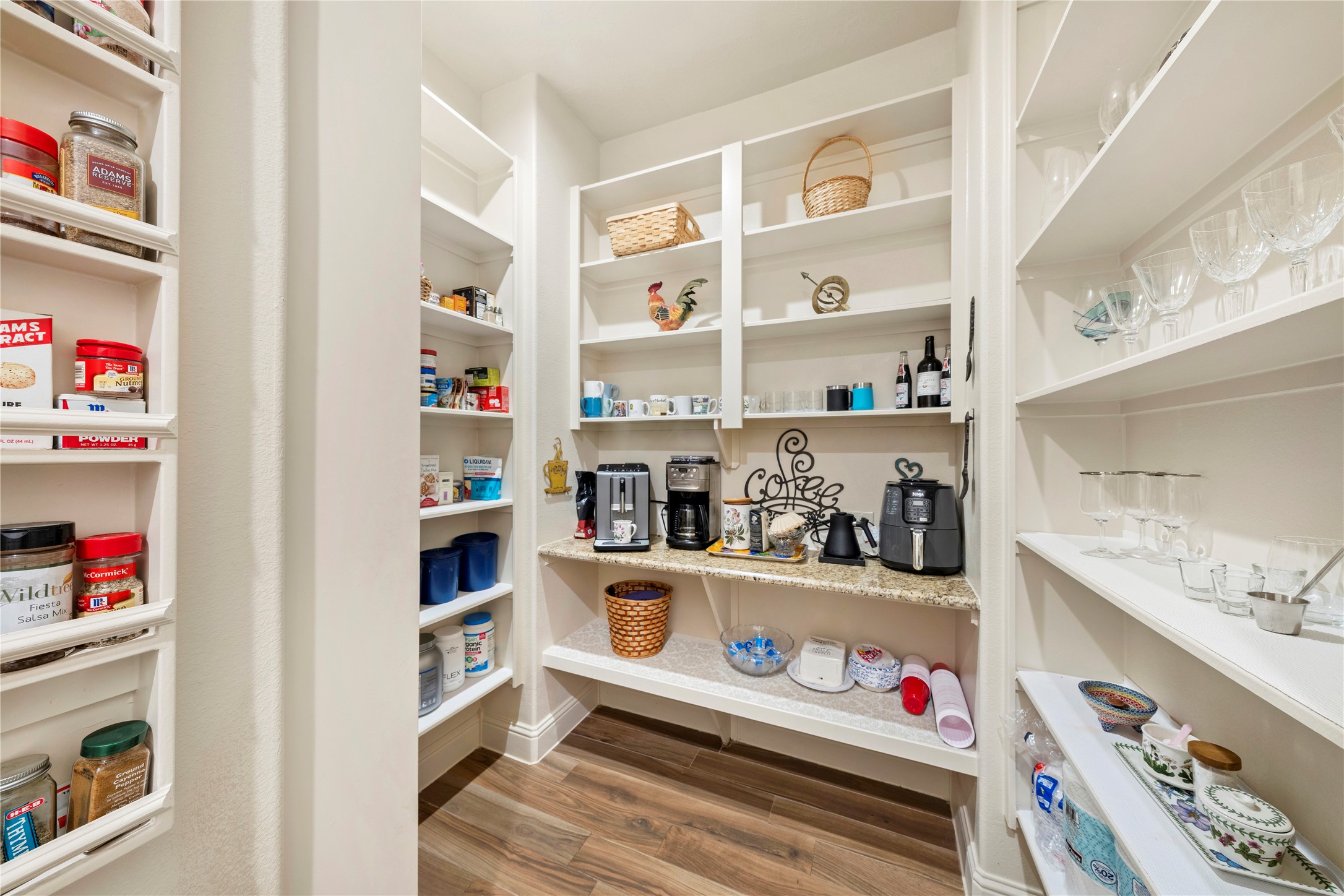 Discover the kitchen's hidden gem with a spacious pantry, perfect for storing all your small appliances and featuring a convenient coffee bar.