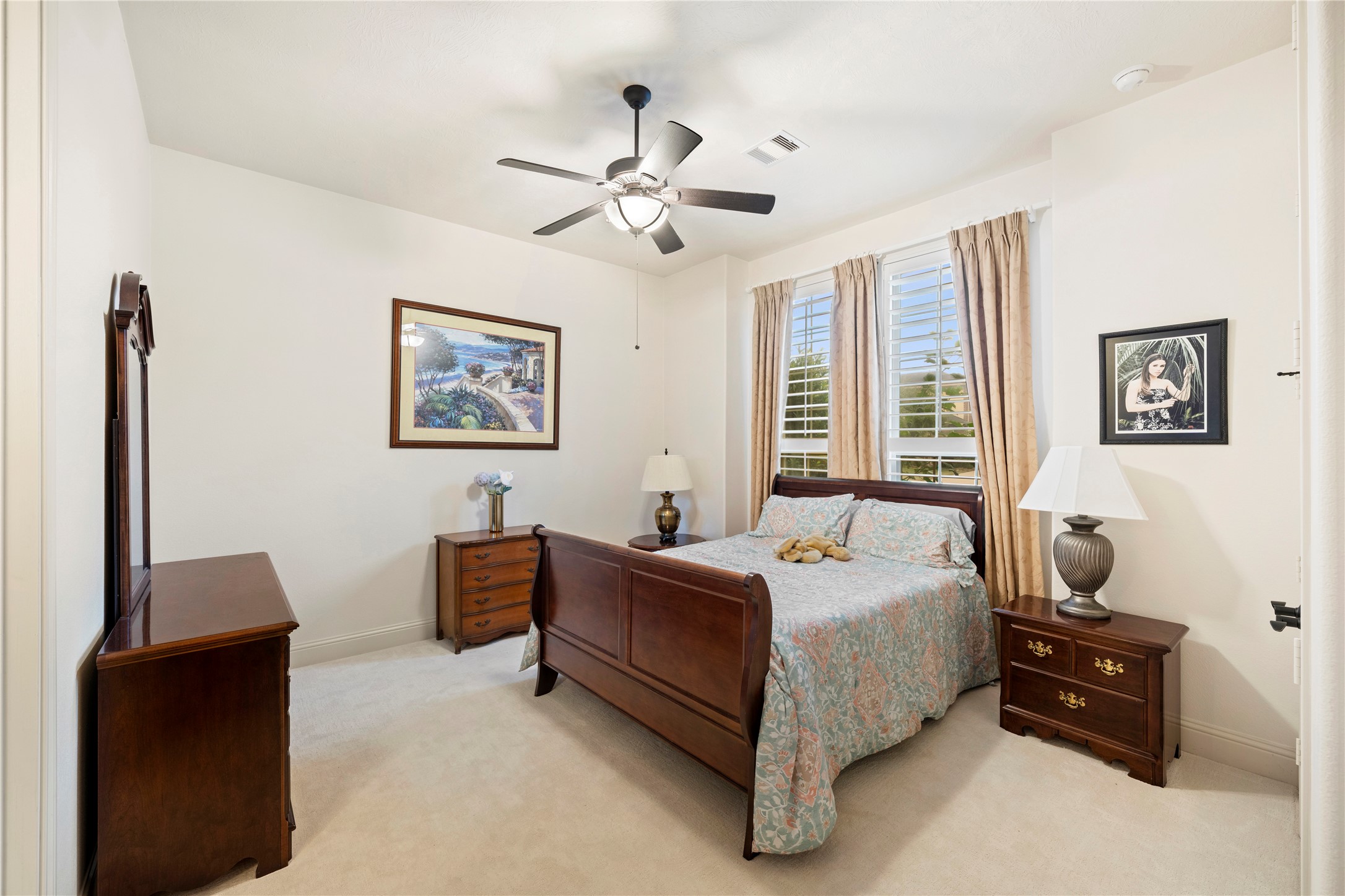 Upon entering, the inviting first secondary bedroom on your right boasts new carpet, elegant plantation shutters, and a spacious closet.