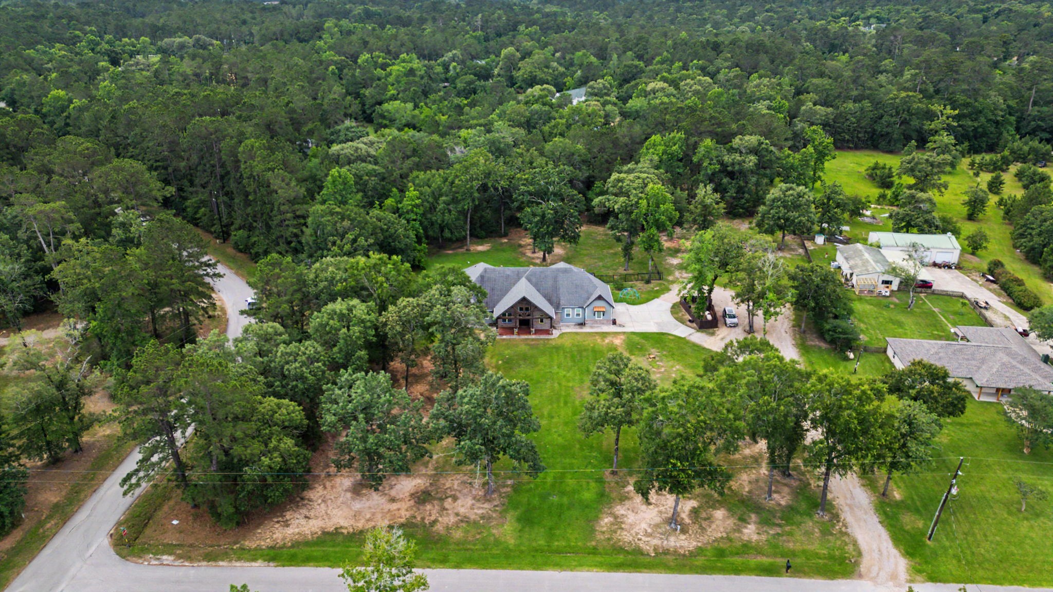 This aerial view captures the expansive grounds, mature trees, and serene setting that make this 5-acre property a private retreat.