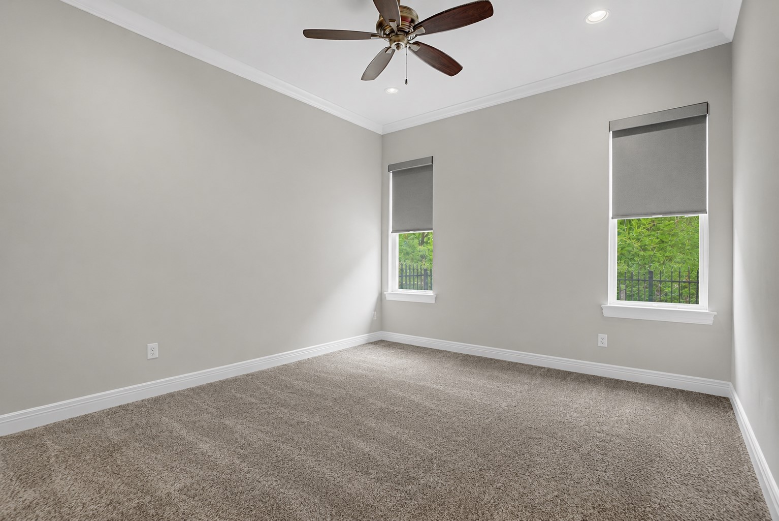 Abundant natural light pours into Secondary Bedroom #3 through dual windows, enhancing the room's spacious and airy feel.