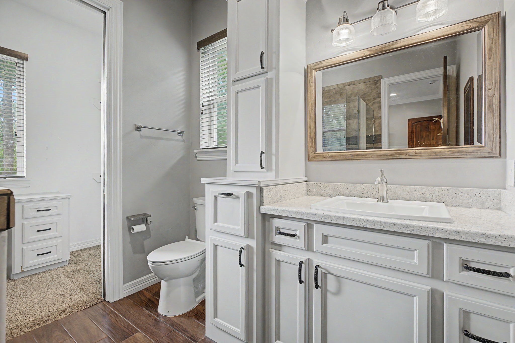 The ensuite bathroom for Secondary Bedroom #1 is light, bright, and offers an abundance of cabinet storage.