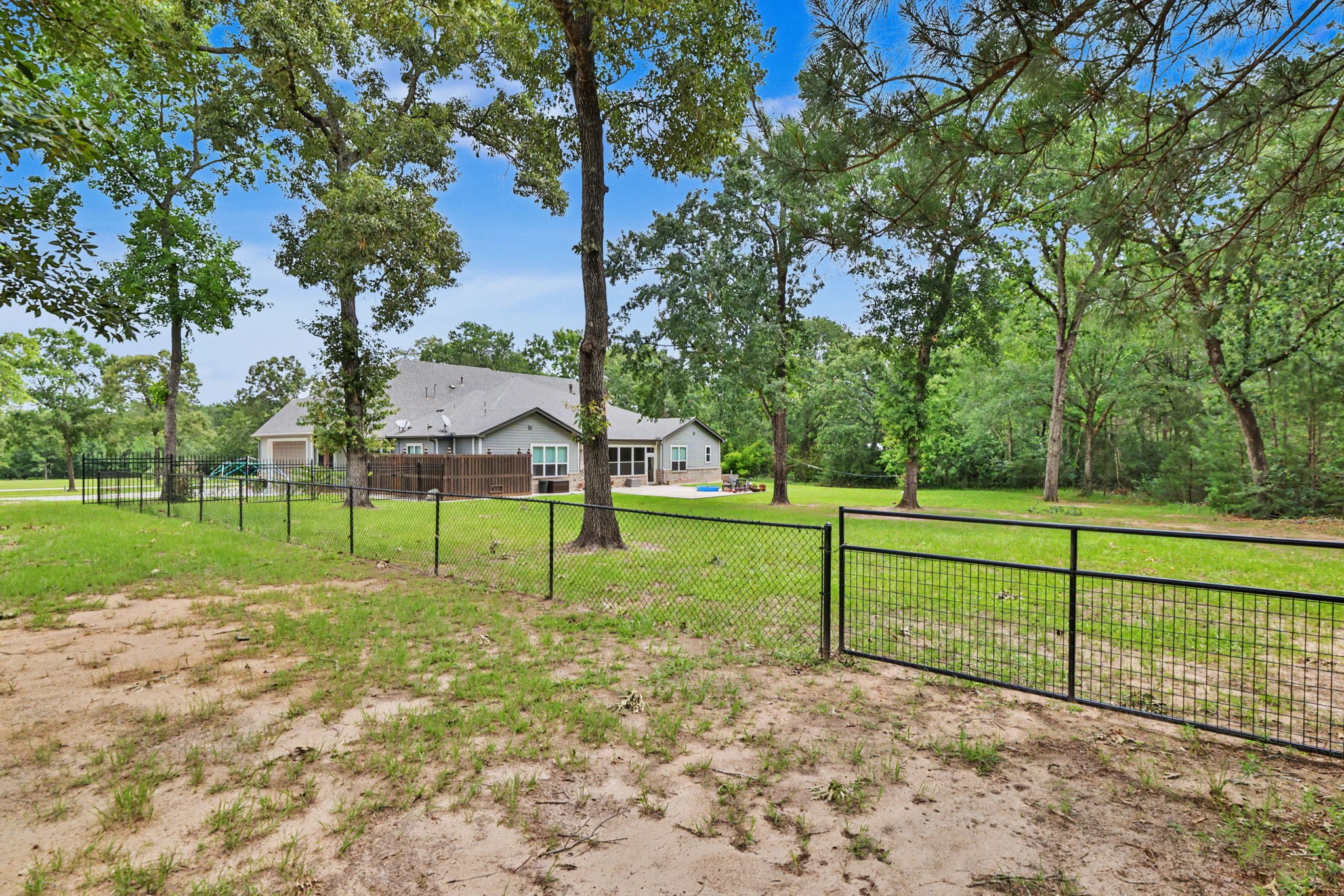The fenced backyard provides a secure space for pets and play, while the property's acreage extends well beyond the fence line, offering even more room to enjoy.