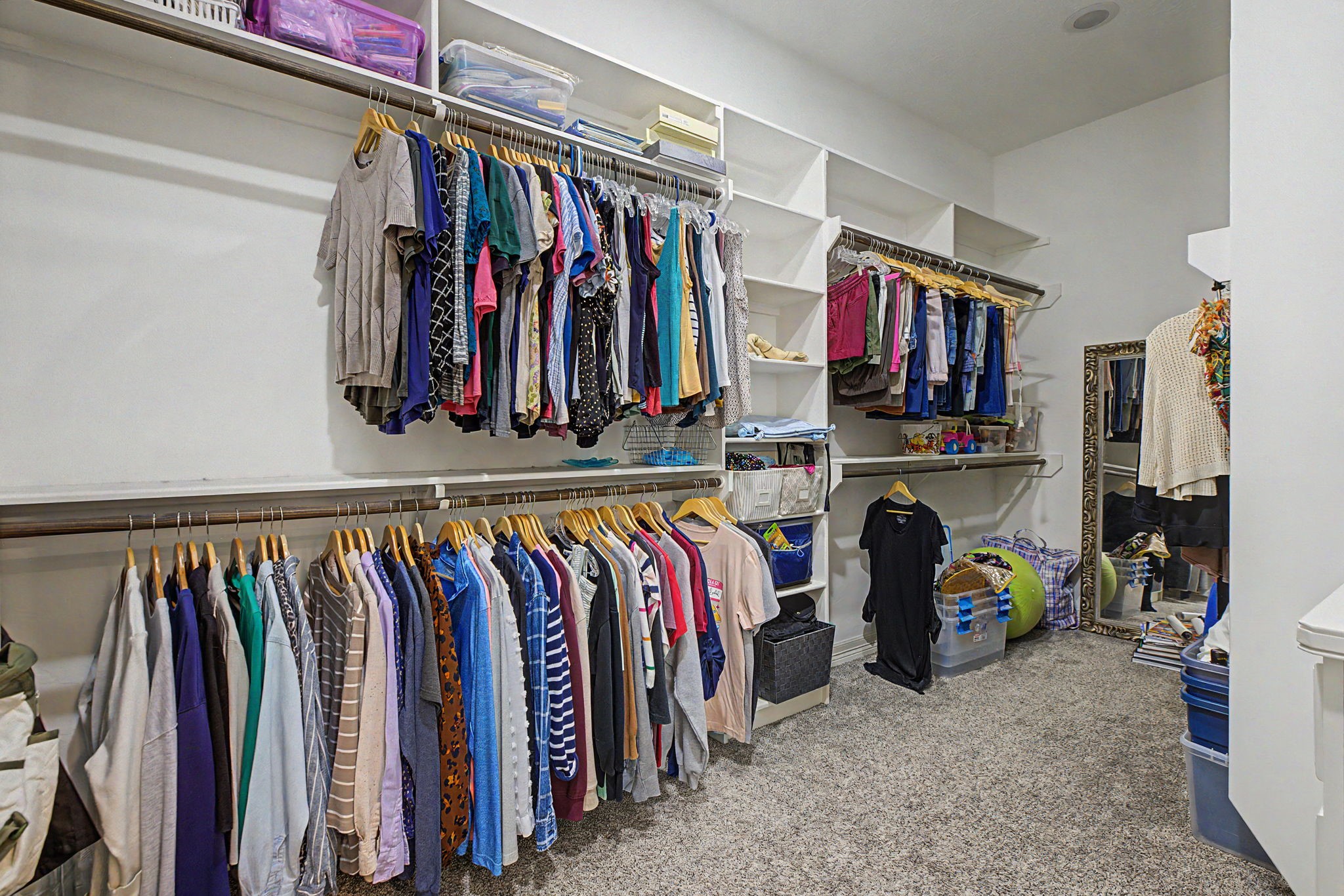 This spacious walk-in primary closet #1 features custom built-ins, providing exceptional storage and organization.
