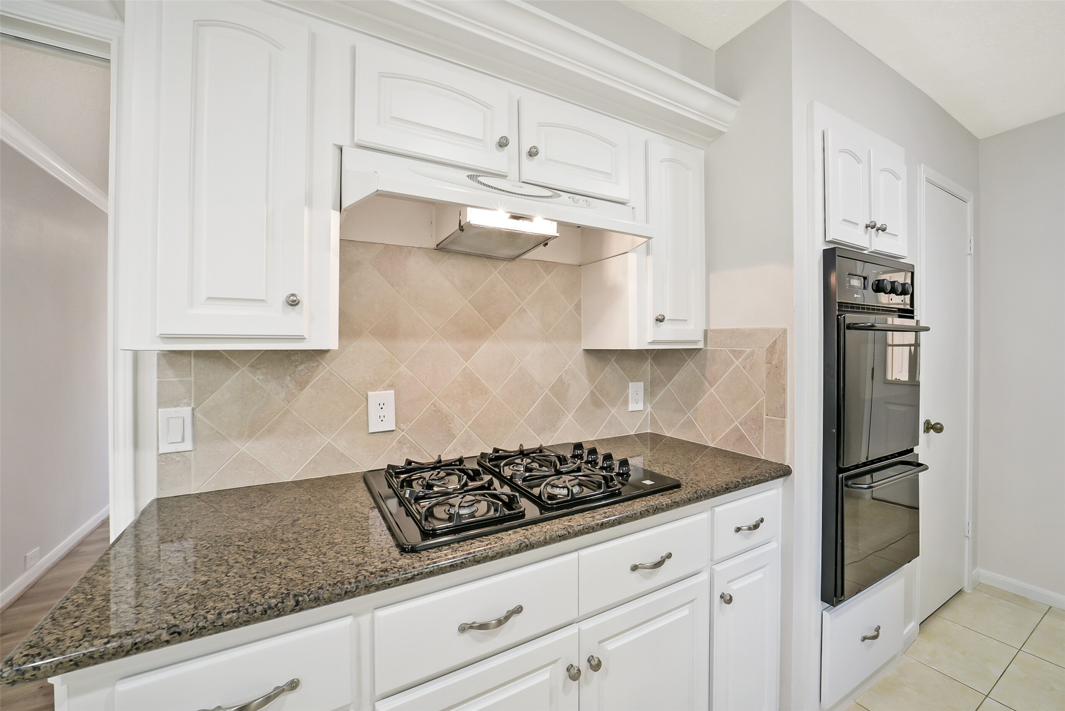 There is a Kenmore four burner gas cooktop and Maytag double electric oven.