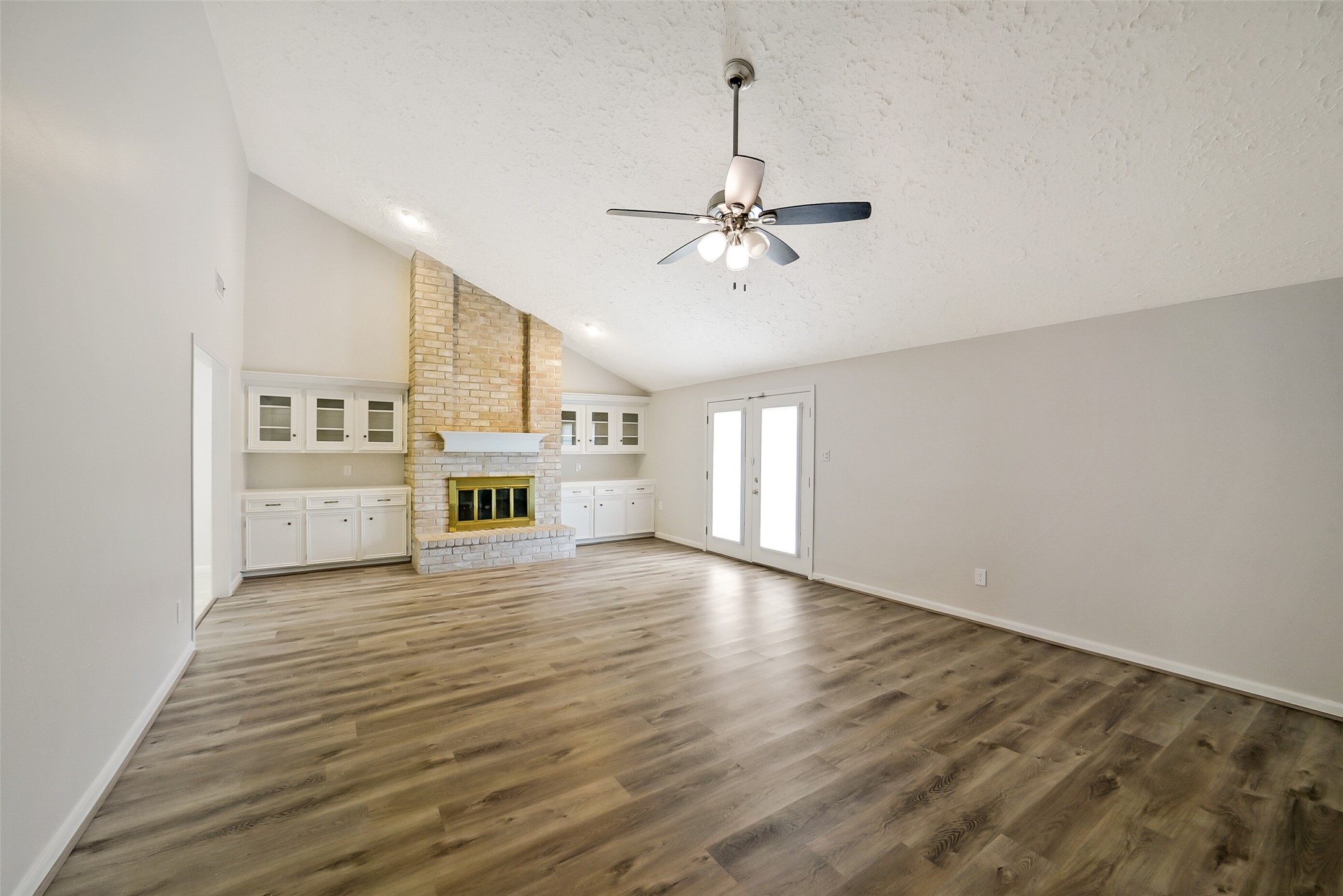 The spacious family room has high ceilings, a ceiling fan, gaslog fireplace, built-ins and access through the French doors to the backyard.