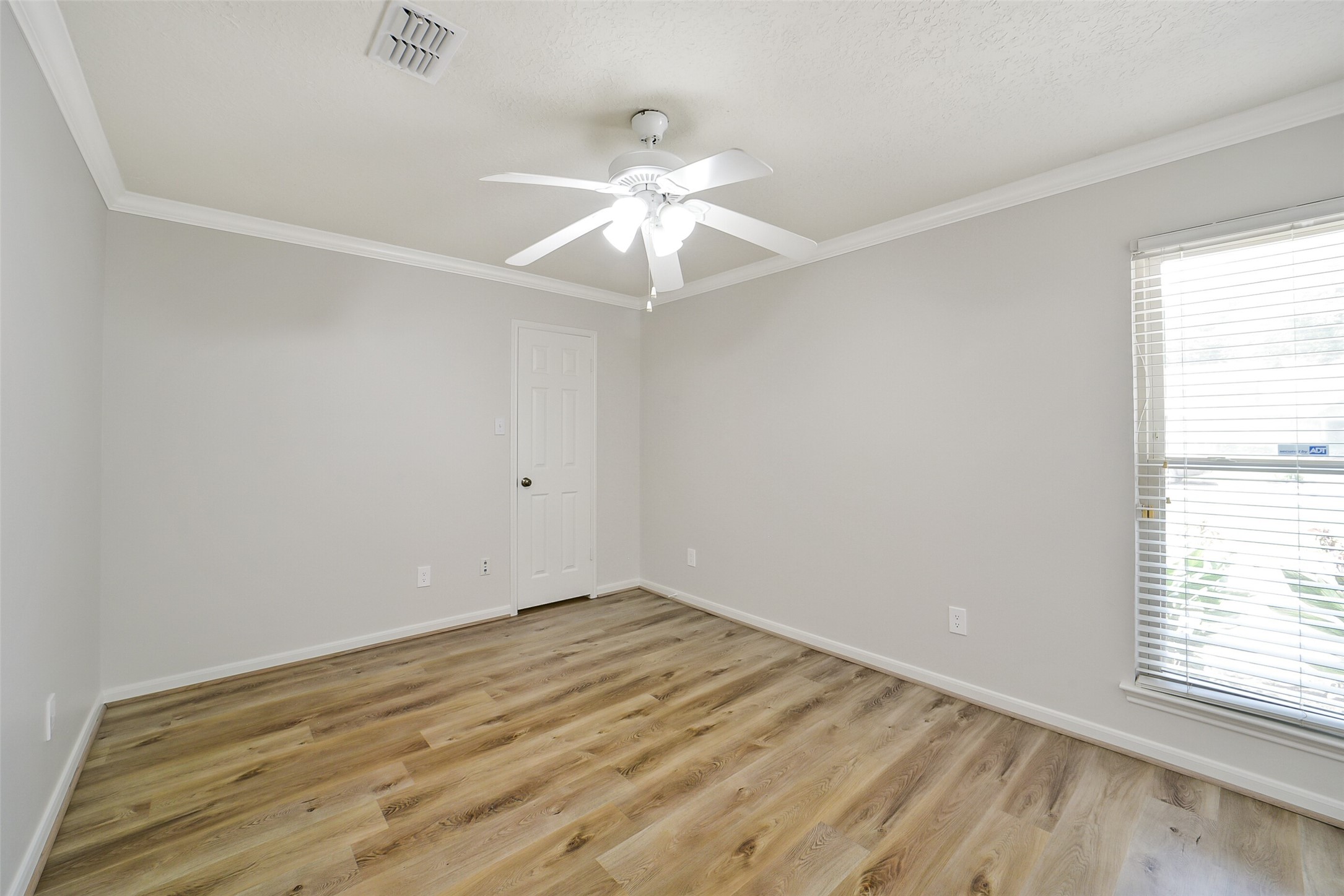 Bedroom #2 has high end laminate floors, crown molding, a ceiling fan and walk-in closet.