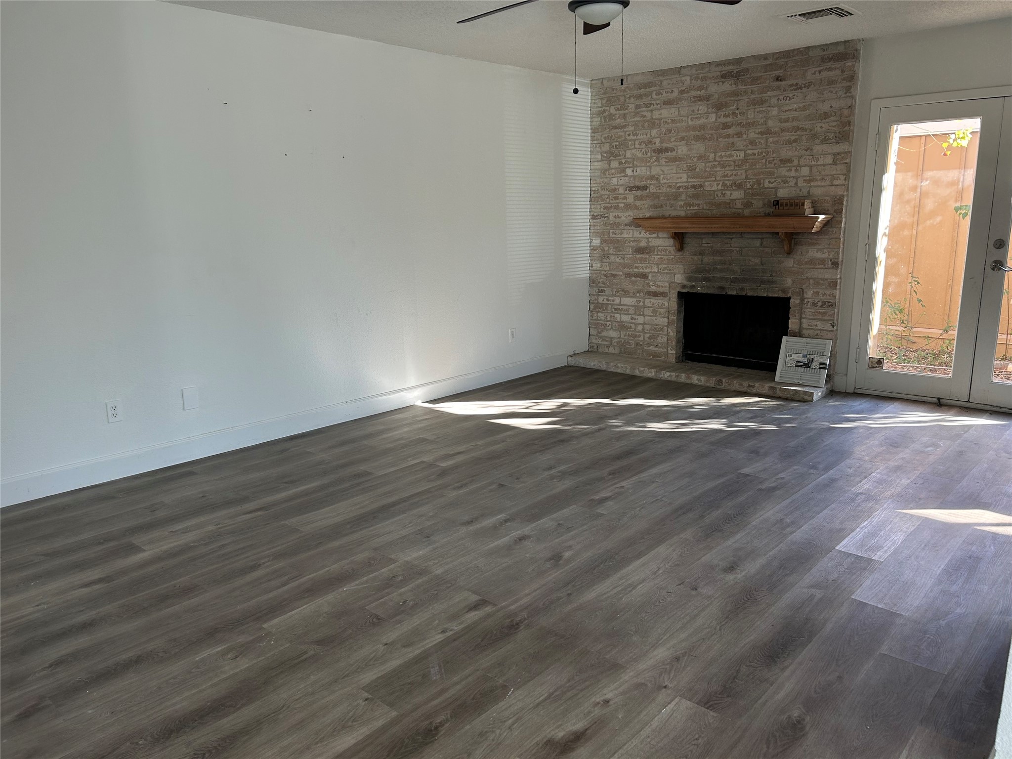 Spacious family room with a lovely fireplace and ceiling fan.