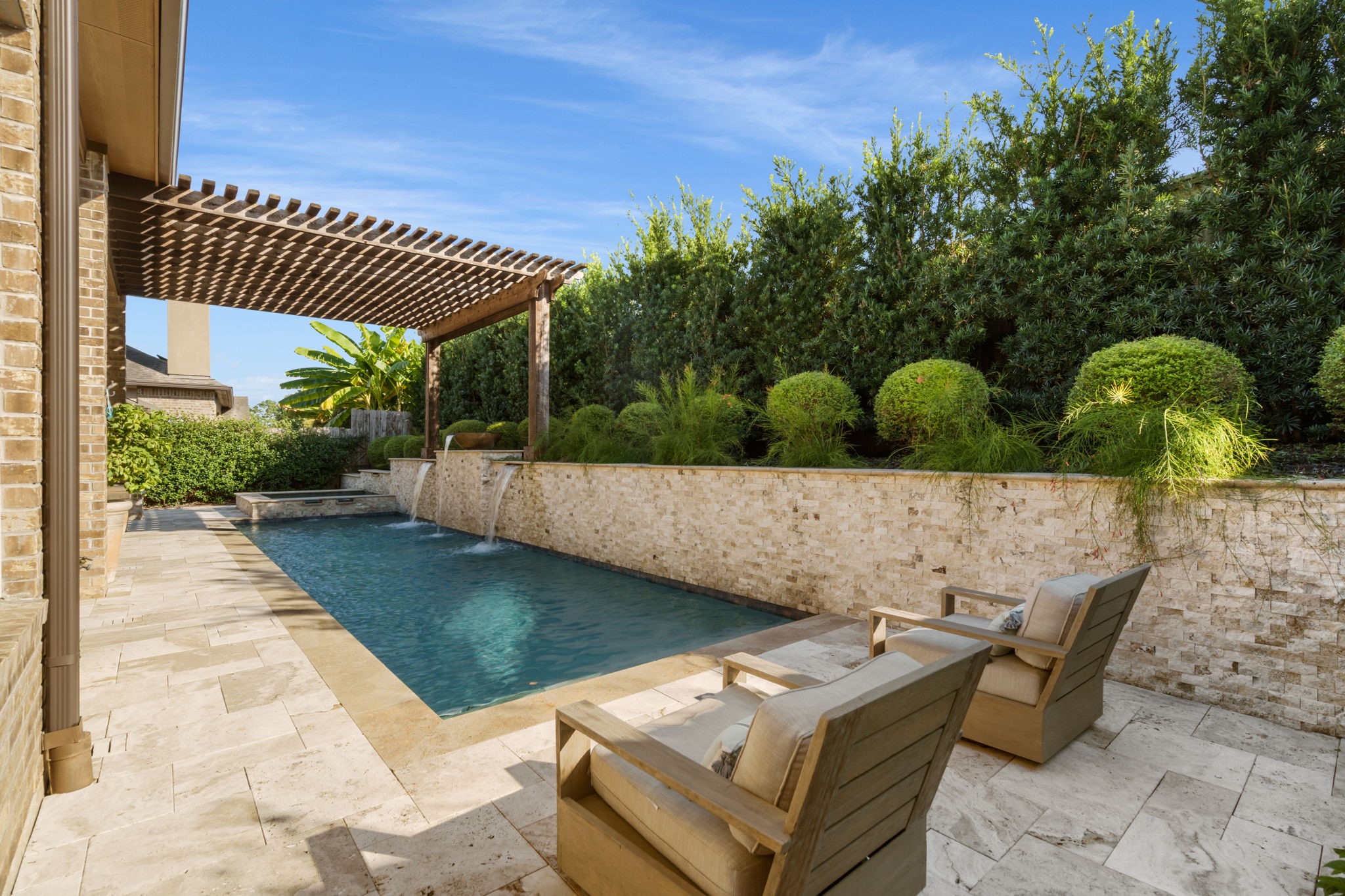 Relax poolside surrounded by lush, mature landscaping that creates a peaceful and private backyard setting.
