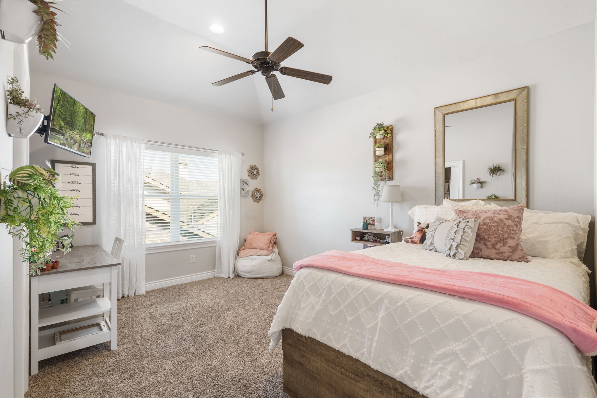 Comfortable upstairs bedroom offers ample space for furnishings, a study area, and everyday relaxation.