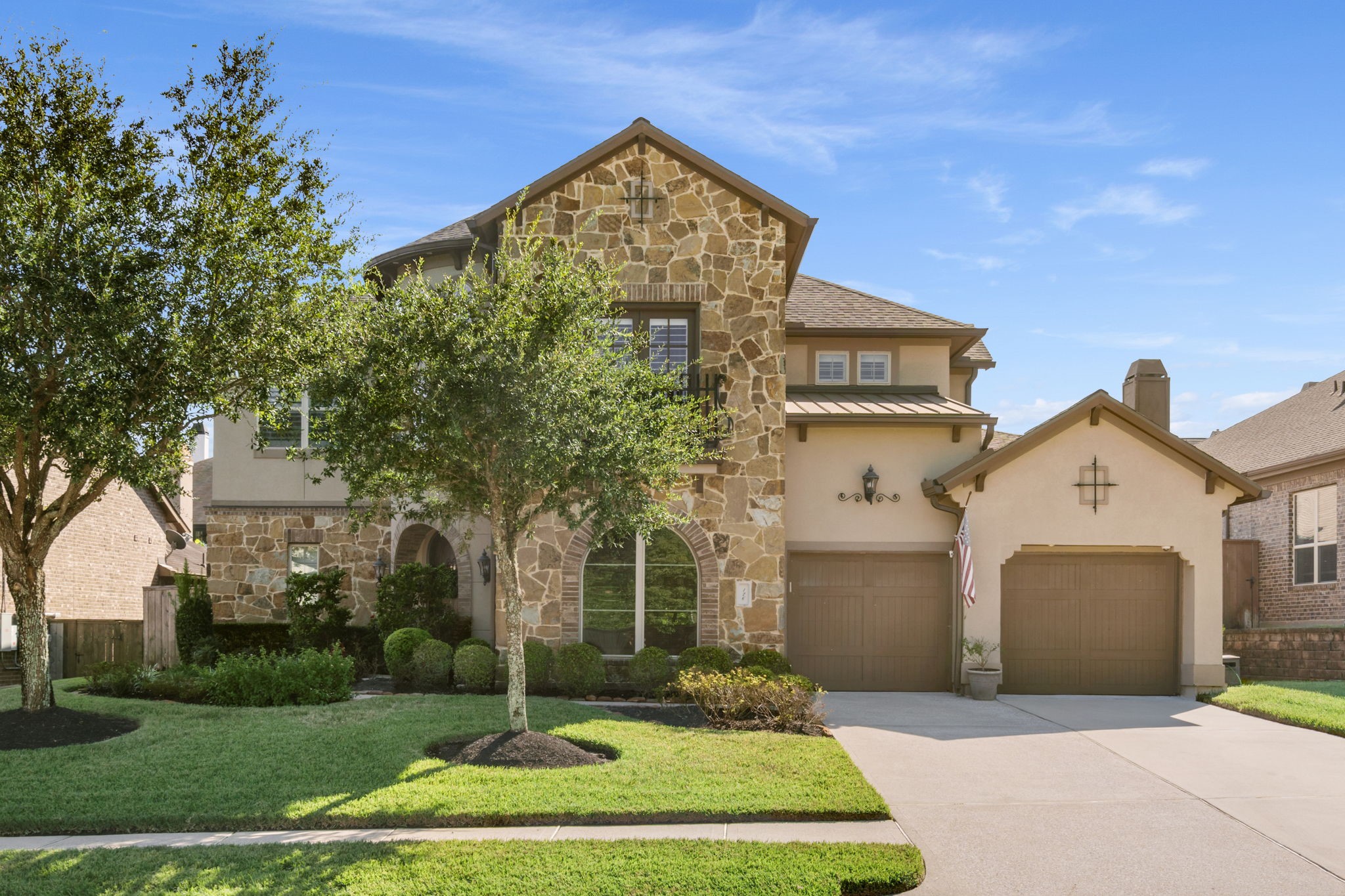Distinctive stone and stucco architecture accented by a charming Juliet balcony with decorative wrought iron railing.
