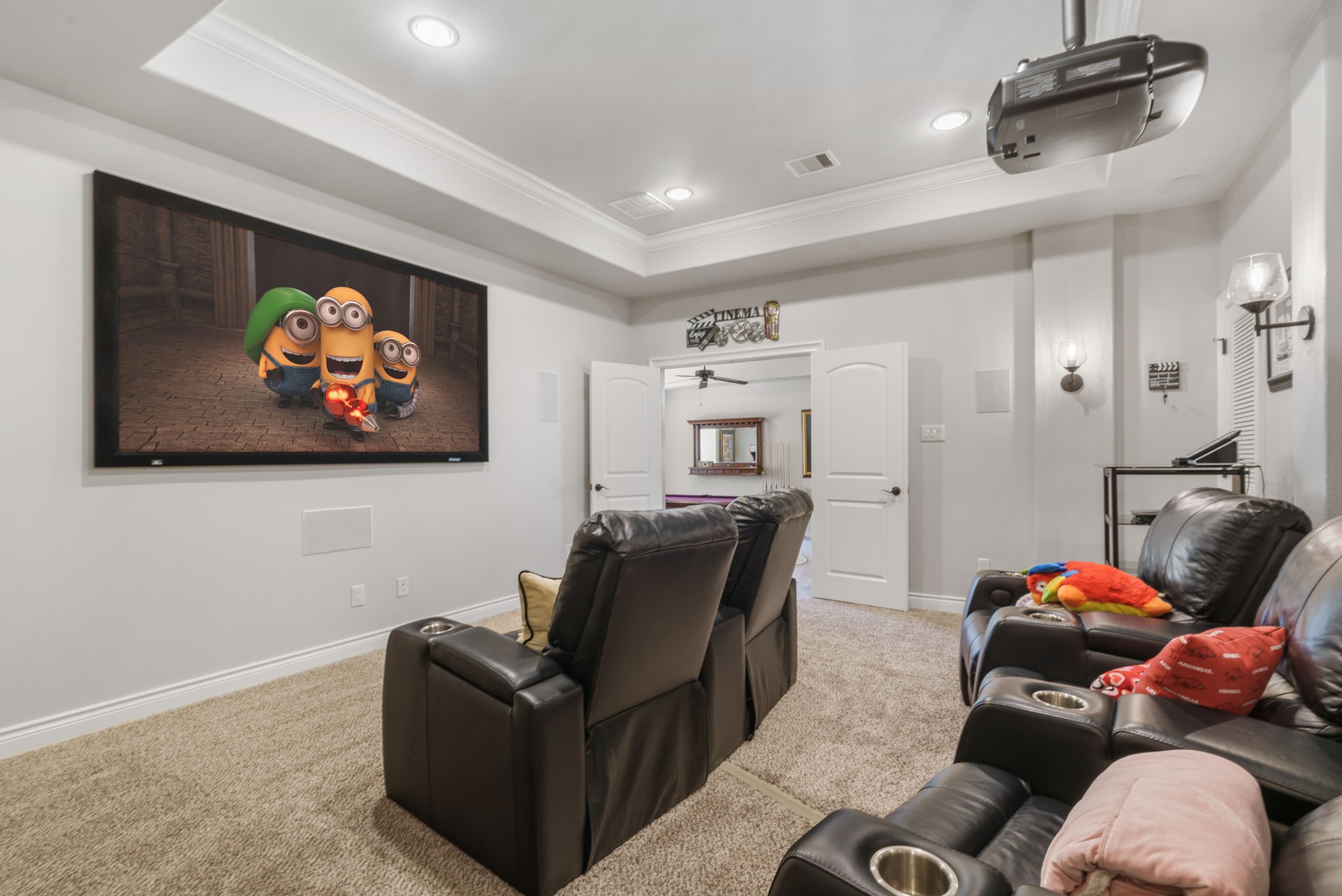 Enjoy the full theater experience with a large projection screen, built-in speakers, and double doors connecting to the game room.