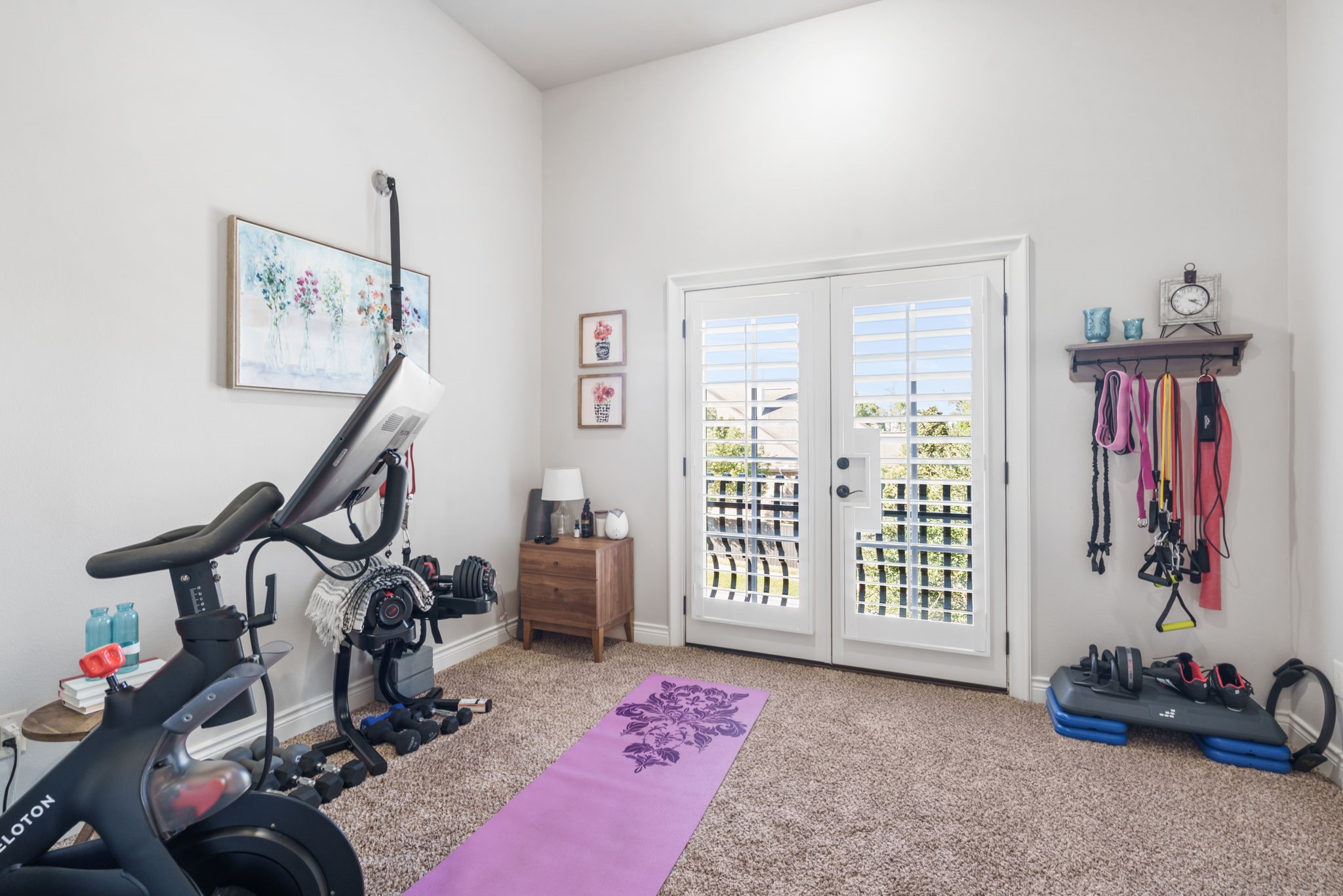 Versatile upstairs bedroom featuring high ceilings and French doors opening to a private balcony.