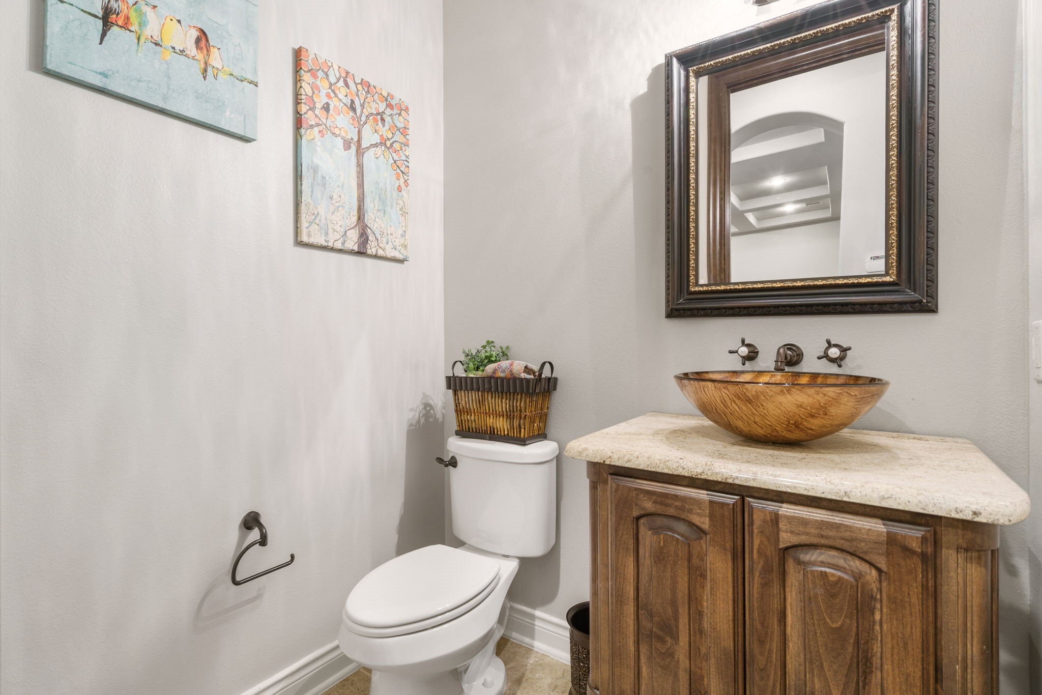 Charming powder bath featuring a decorative vessel sink, granite countertop, and wall-mounted faucet.