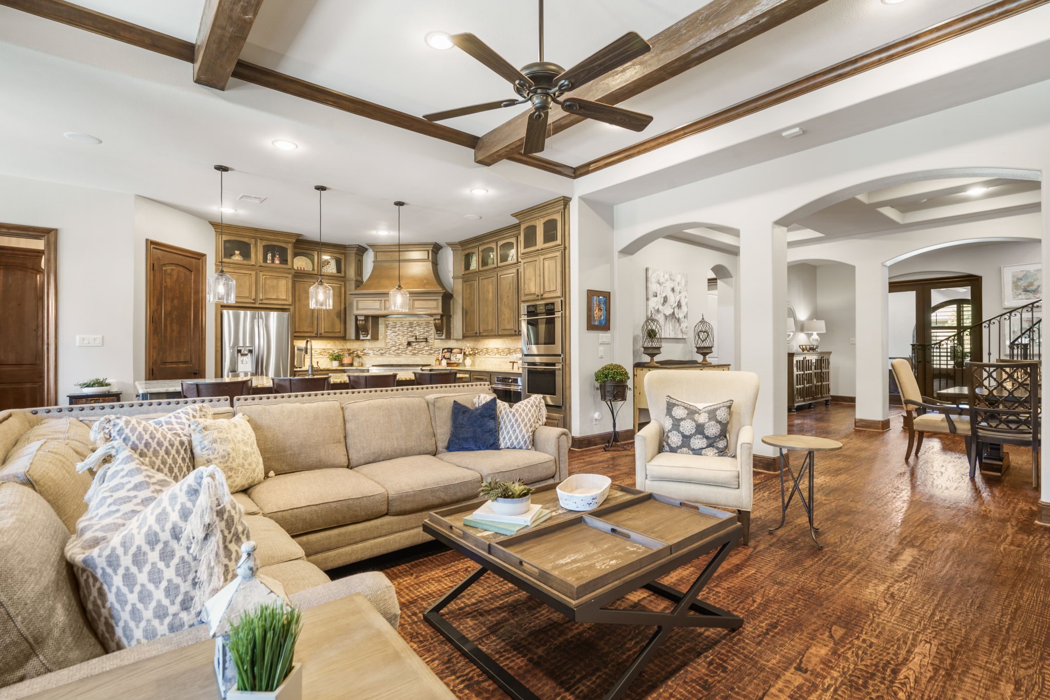 Impressive ceiling beams and rich hardwood flooring add warmth and architectural character to the spacious family room.