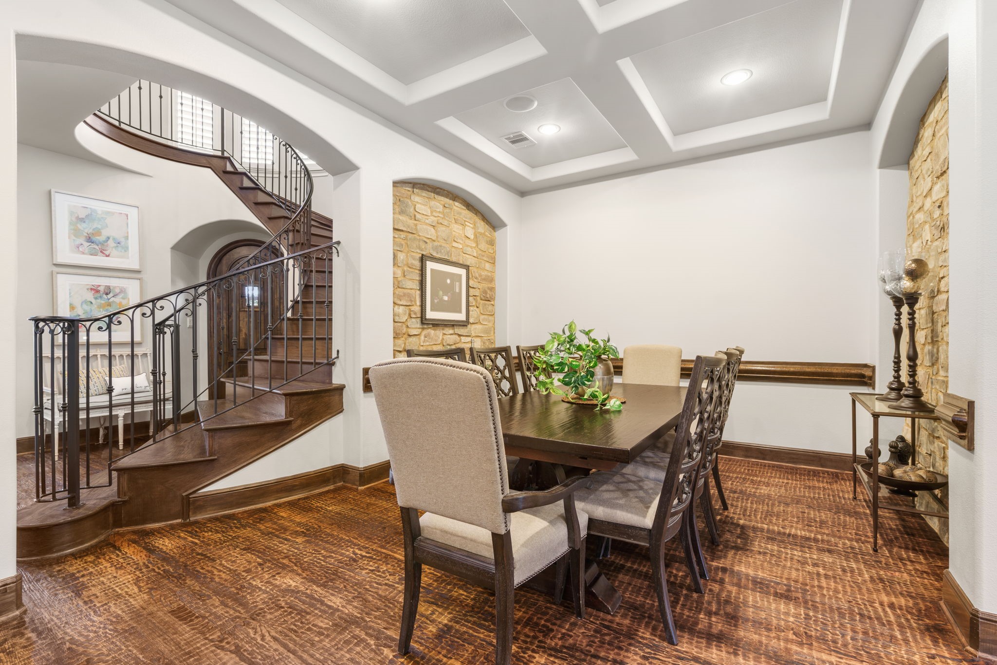 Elegant formal dining room with a distinctive coffered ceiling, recessed lighting, and graceful arched openings.