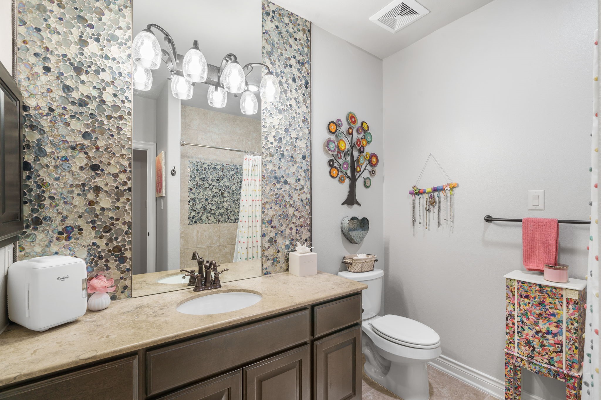 Beautifully detailed full bathroom featuring decorative mosaic tile accents, granite countertops, and a tub/shower combination.