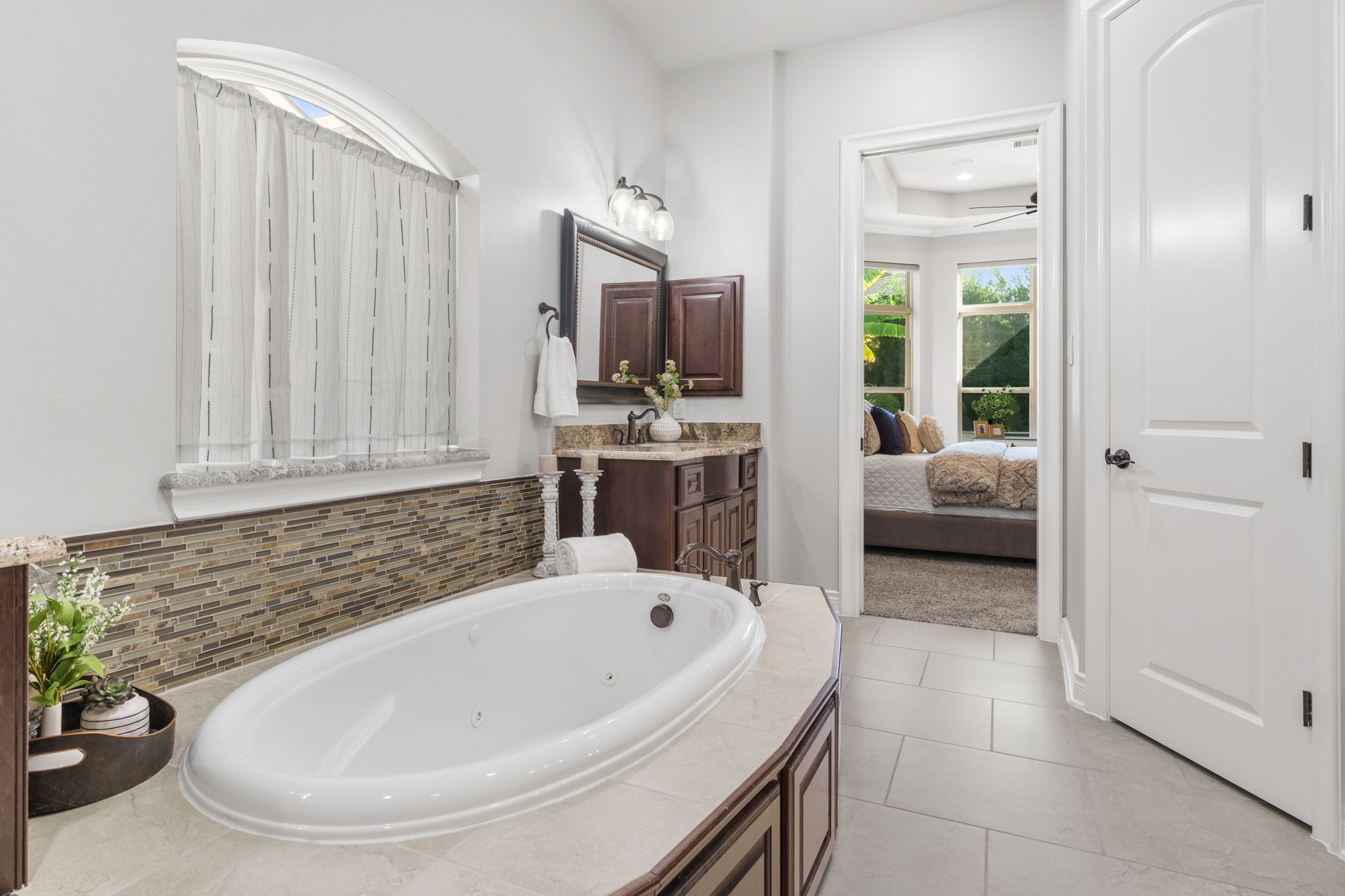 Relax in the jetted soaking tub, beautifully accented by decorative mosaic tile and an arched window.