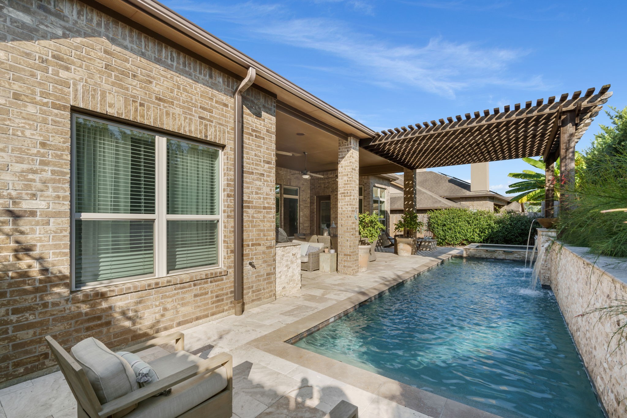 Beautiful stone decking and a spacious pergola provide multiple areas to lounge and enjoy the outdoors.