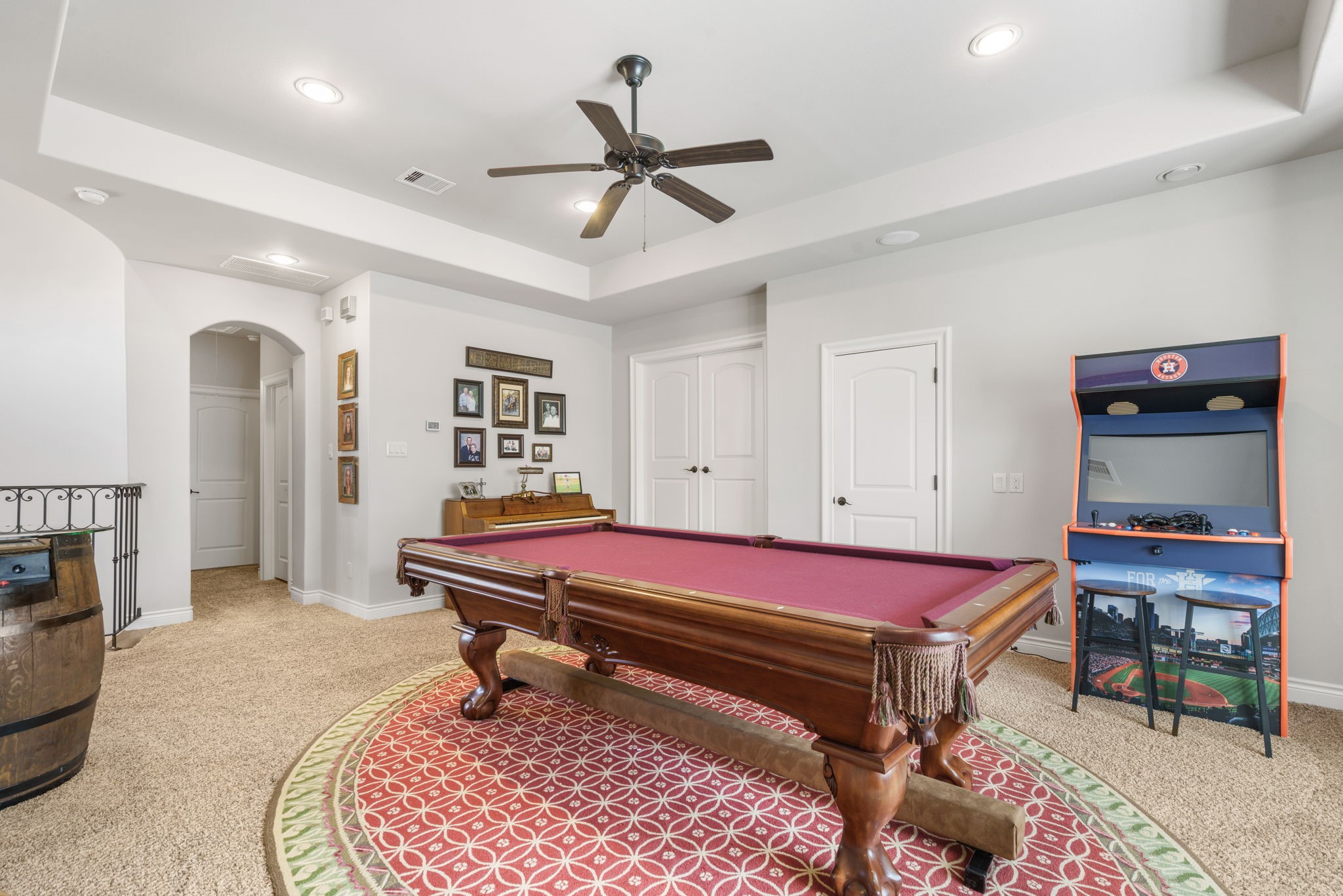 Versatile second-floor gathering space with tray ceiling, recessed lighting, and convenient access to the upstairs bedrooms.