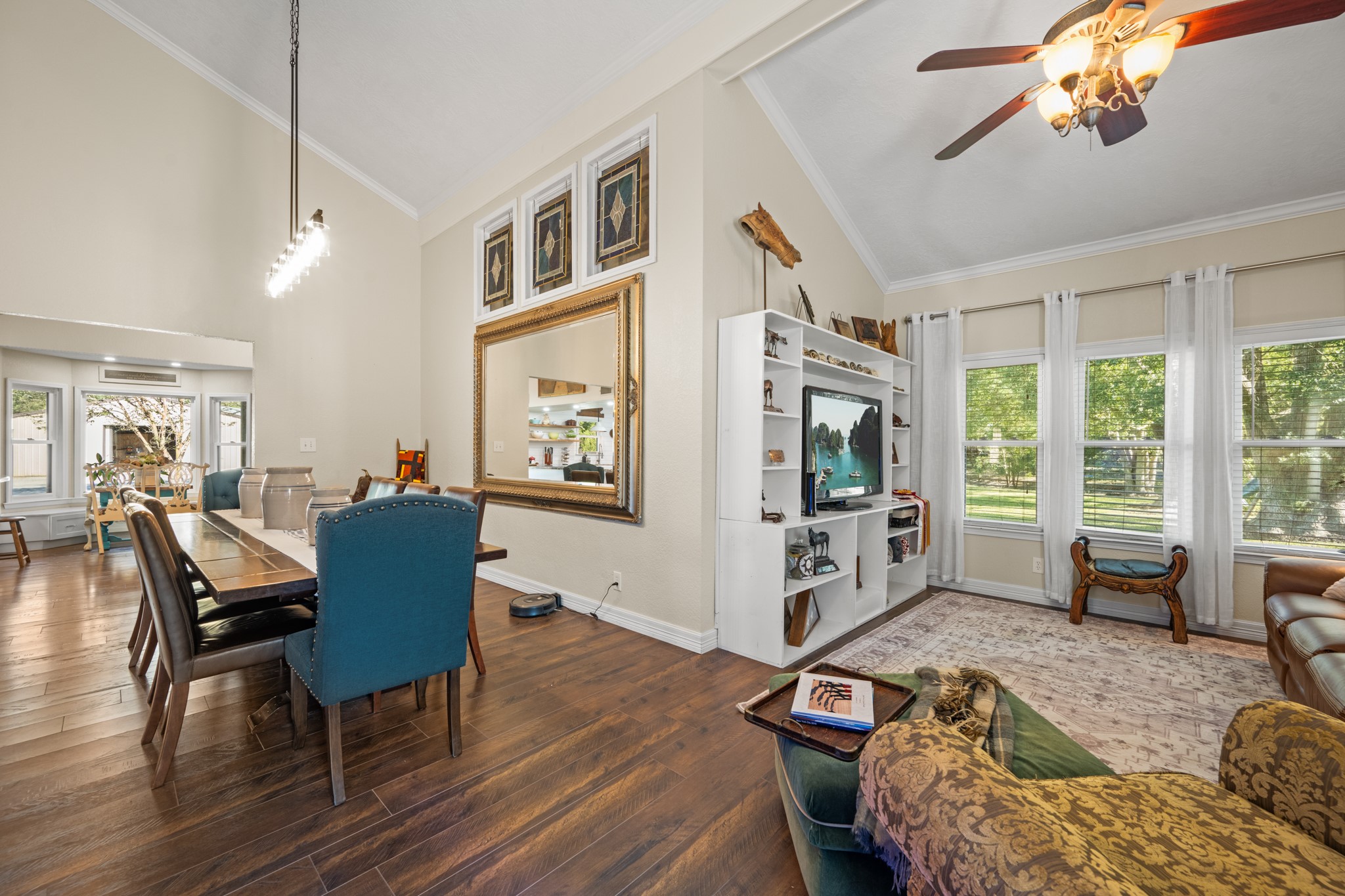 An open, flowing layout connects the dining area and family room, enhanced by high ceilings, abundant natural light, and expansive windows overlooking the property's greenery. An open, flowing layout connects the dining area and family room, enhanced by high ceilings, abundant natural light, and expansive windows overlooking the property's greenery.