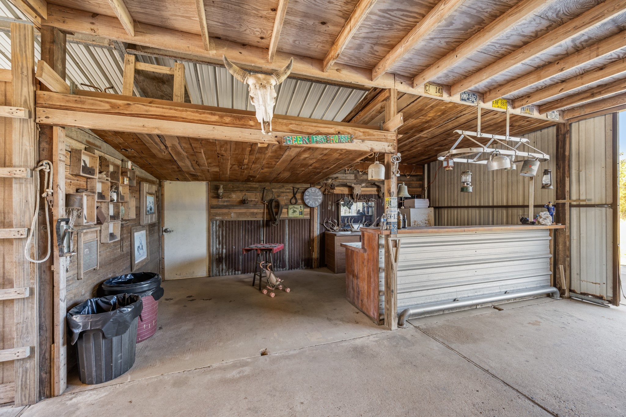Bring your friends together in this one-of-a-kind rustic gathering space featuring a Western-inspired bar, corrugated metal accents, exposed wood beams, decorative lighting, and overhead loft.