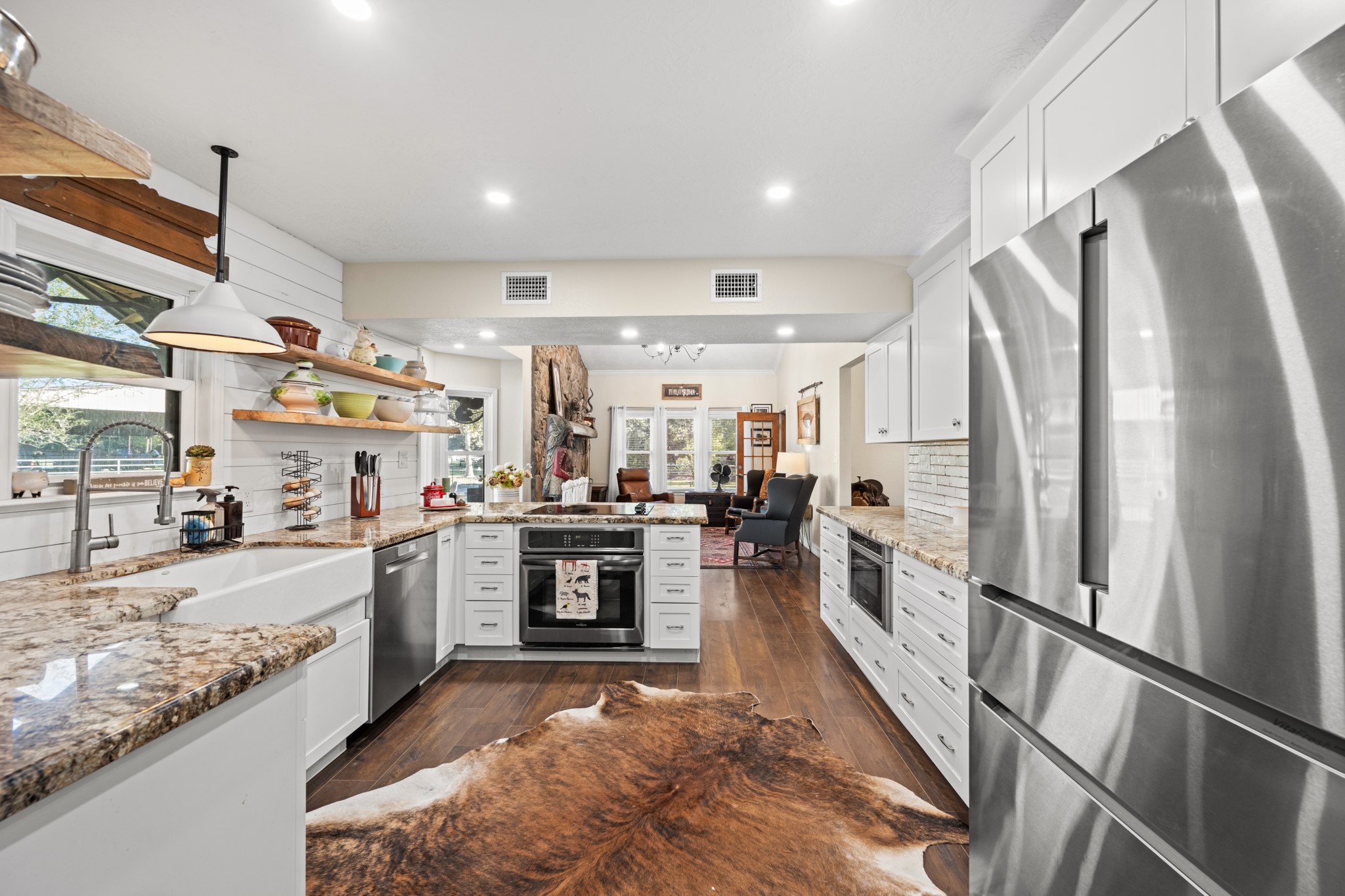 A spacious, thoughtfully designed kitchen features stainless steel appliances, abundant cabinetry, granite countertops, and an open connection to the living area.