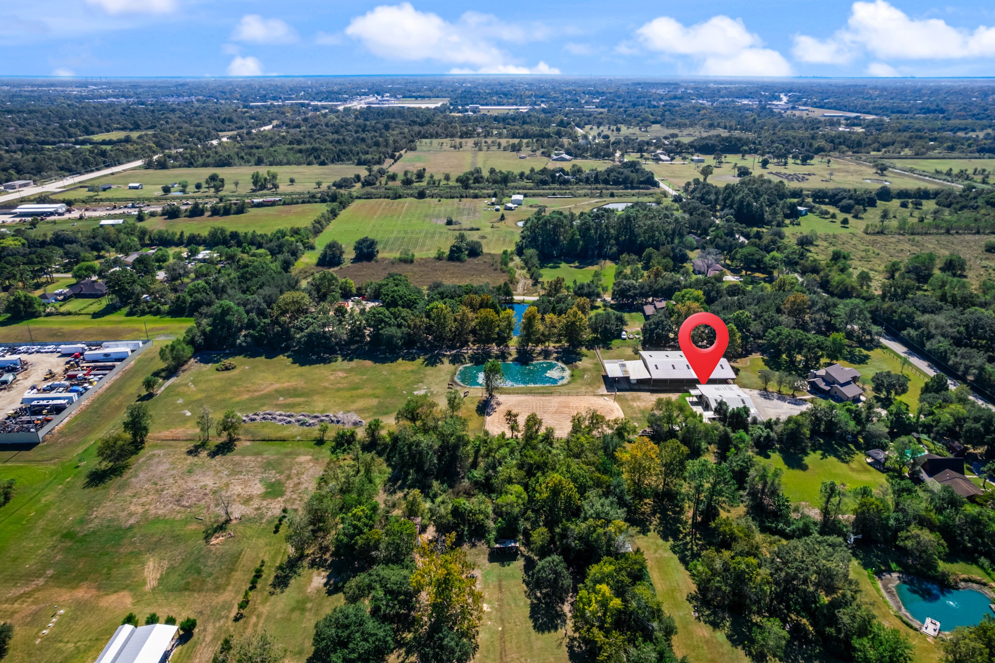 A stunning aerial perspective highlights the property's spacious grounds, picturesque pond, open pasture, and equestrian facilities. Surrounded by mature trees and scenic countryside, this horse property offers a wonderful combination of rural charm, recreational opportunities, and convenient access to nearby amenities.