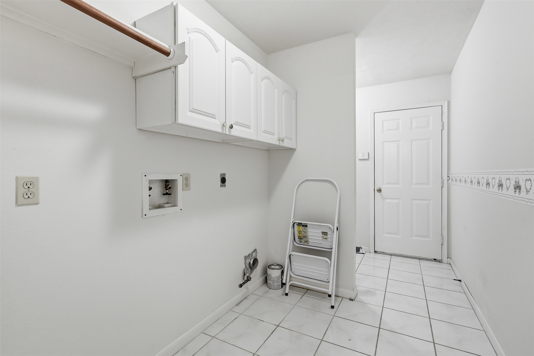 Bright and organized with built-in cabinetry, hanging rod, and full washer/dryer hookups