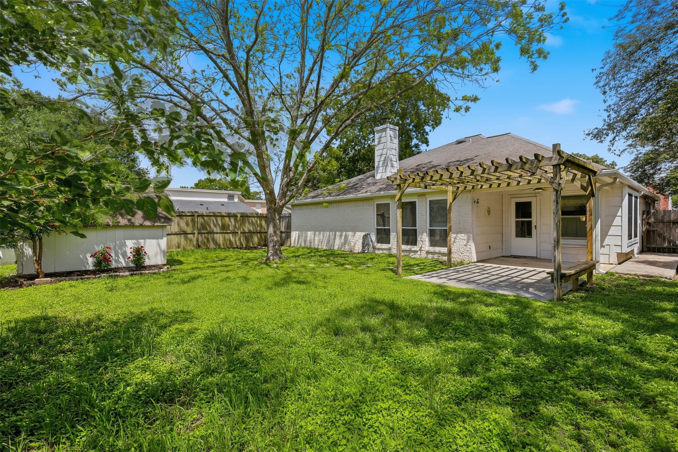 Expansive backyard featuring a mature shade tree & privacy fencing