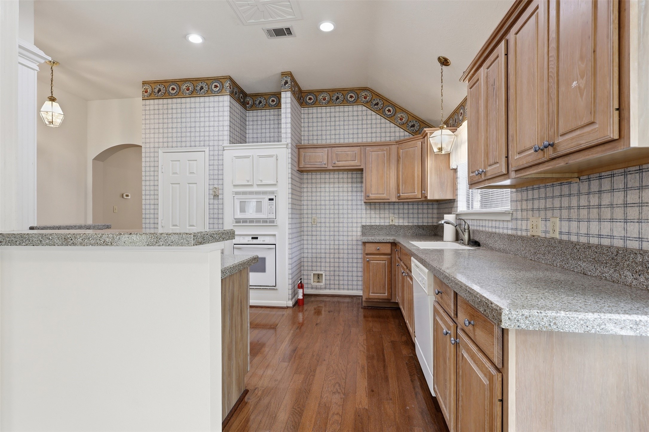 Light wood cabinetry, granite countertops, and a NEW DISHWASHER!
