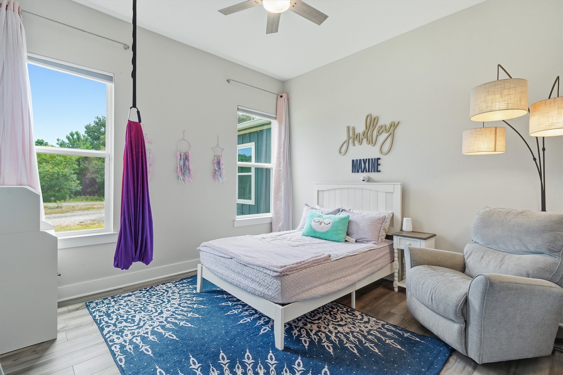 Third bedroom with high ceilings and two windows overlooking side yard and garage