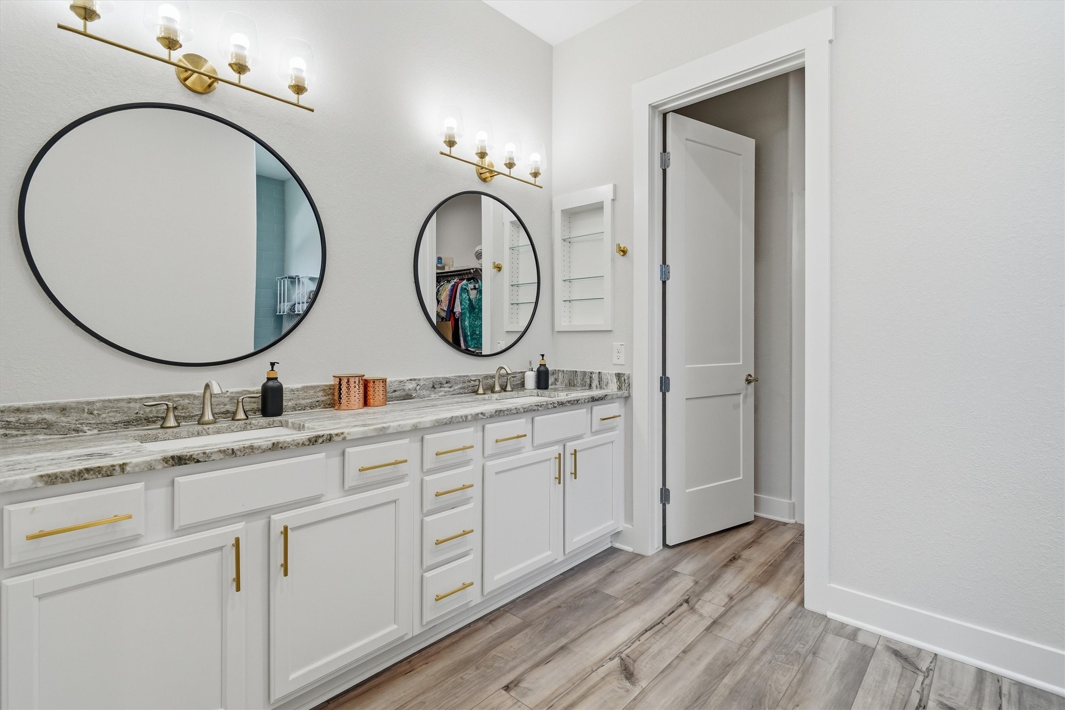 Primary en suite featuring double sinks, framed mirrors and tons of storage