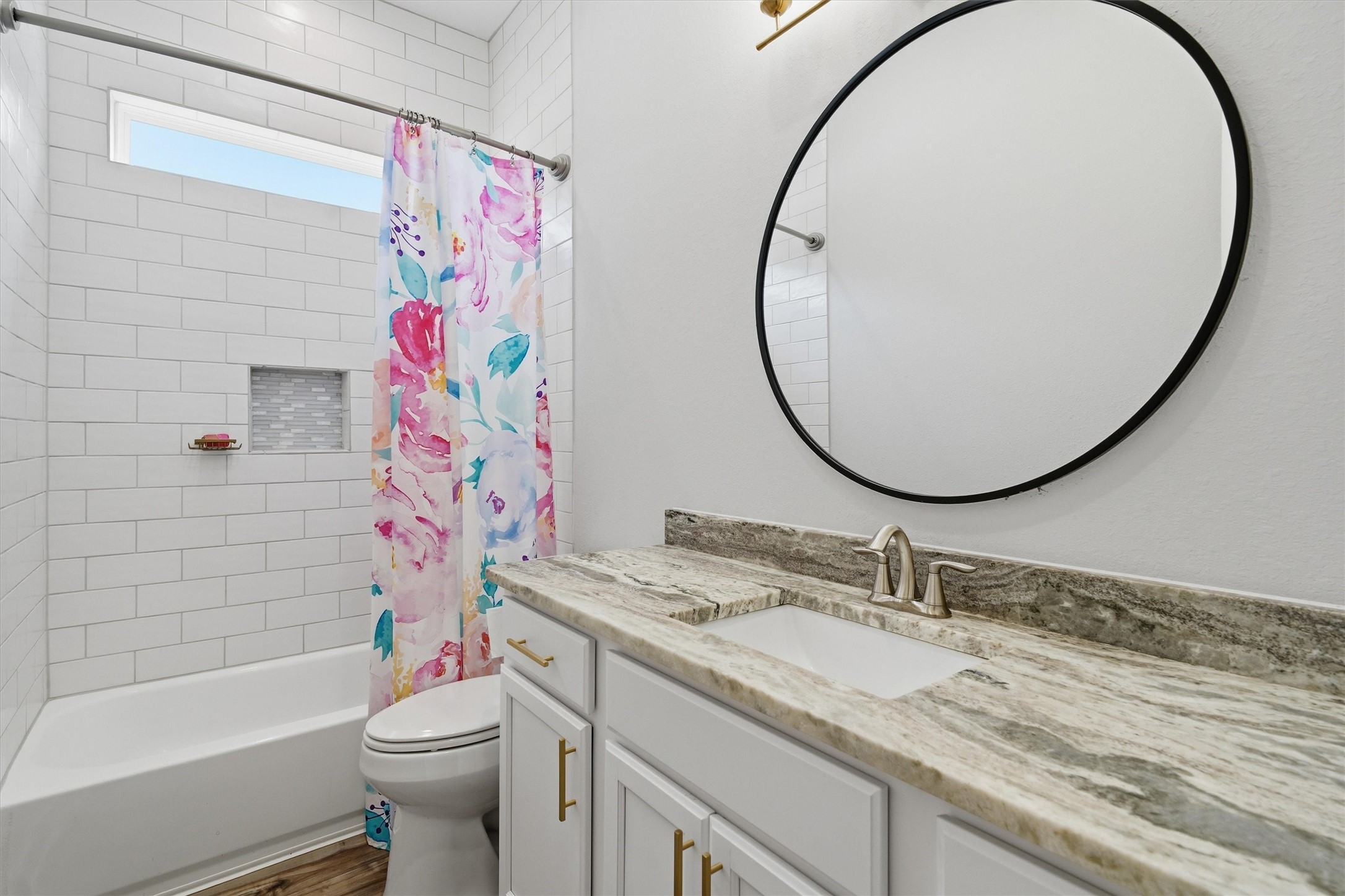 Second full bath with fully tiled tub/shower combo- all the way to the ceiling! Leathered granite countertop and framed mirror