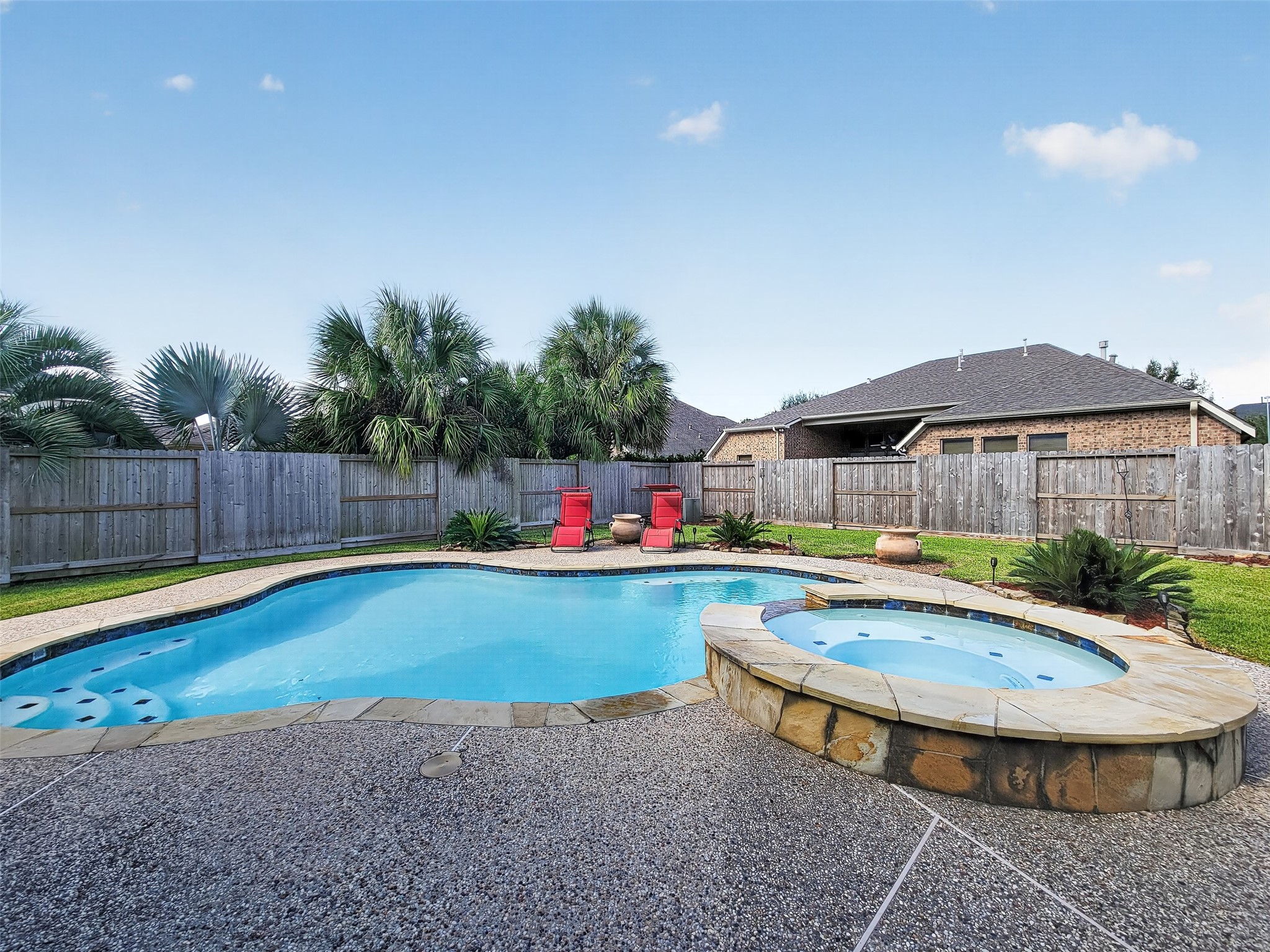 Enjoy a private oasis with a sparkling pool and spa, surrounded by lush greenery and a spacious patio, perfect for relaxation and entertaining.