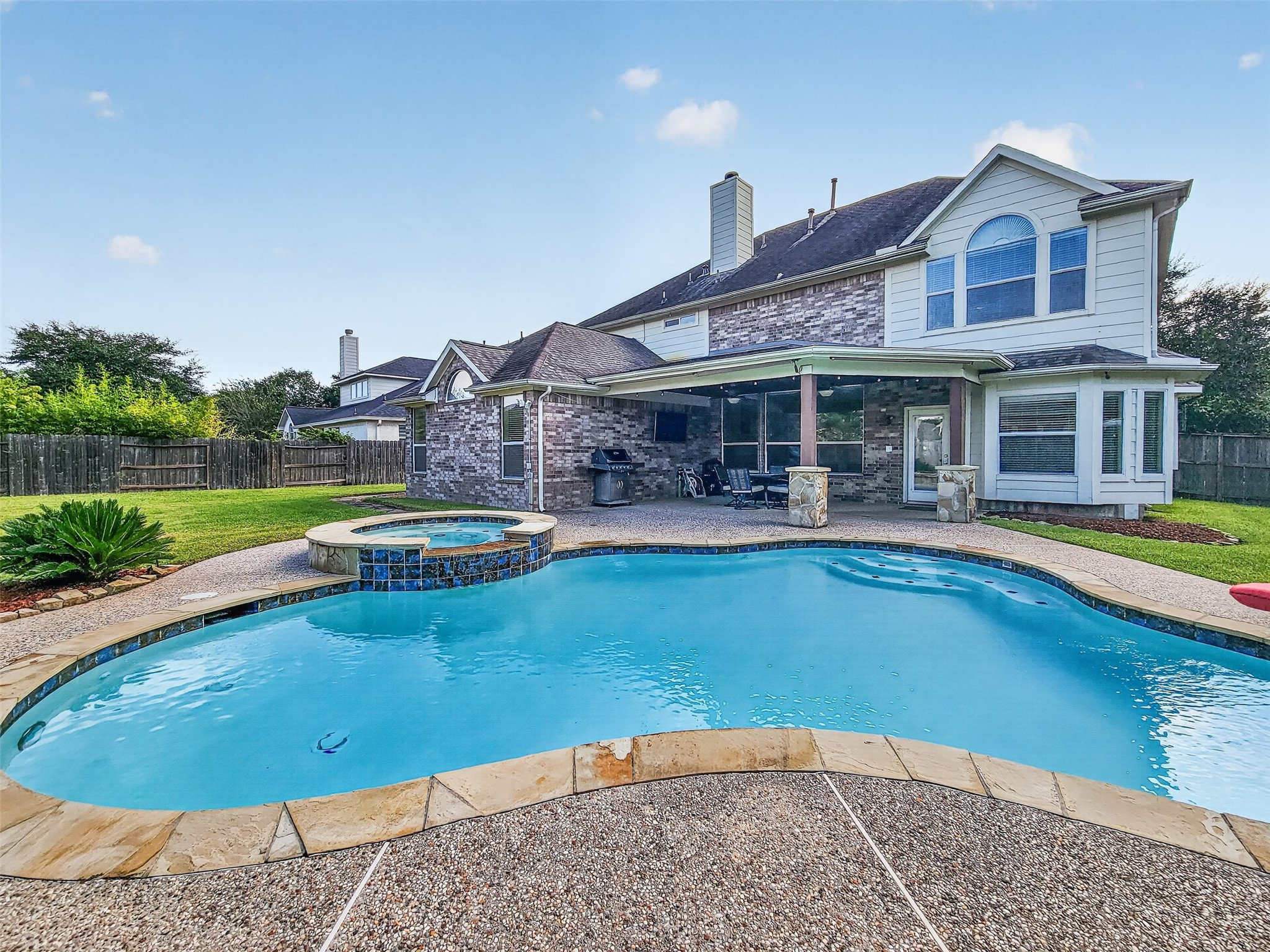 Dive into luxury with this stunning backyard featuring a sparkling pool and attached spa, perfect for relaxation and entertaining.