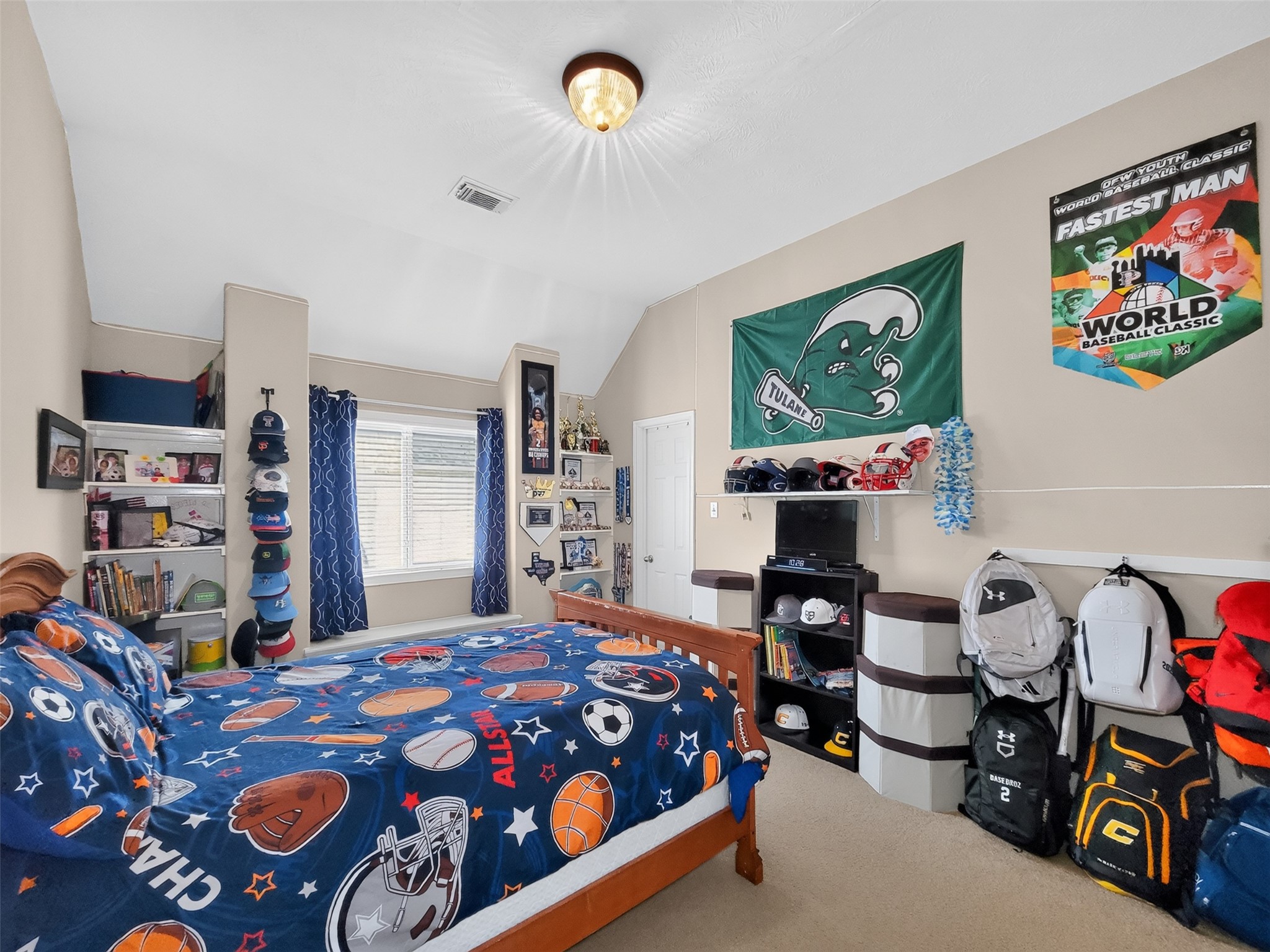 Bright and spacious bedroom with sports-themed decor, featuring a cozy bed, ample shelving for storage, and vibrant wall art, perfect for a young sports enthusiast.