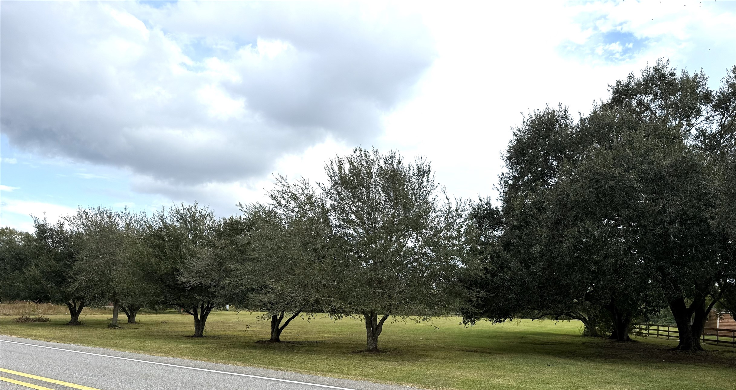 Beautiful oak trees line the front and partially up the side