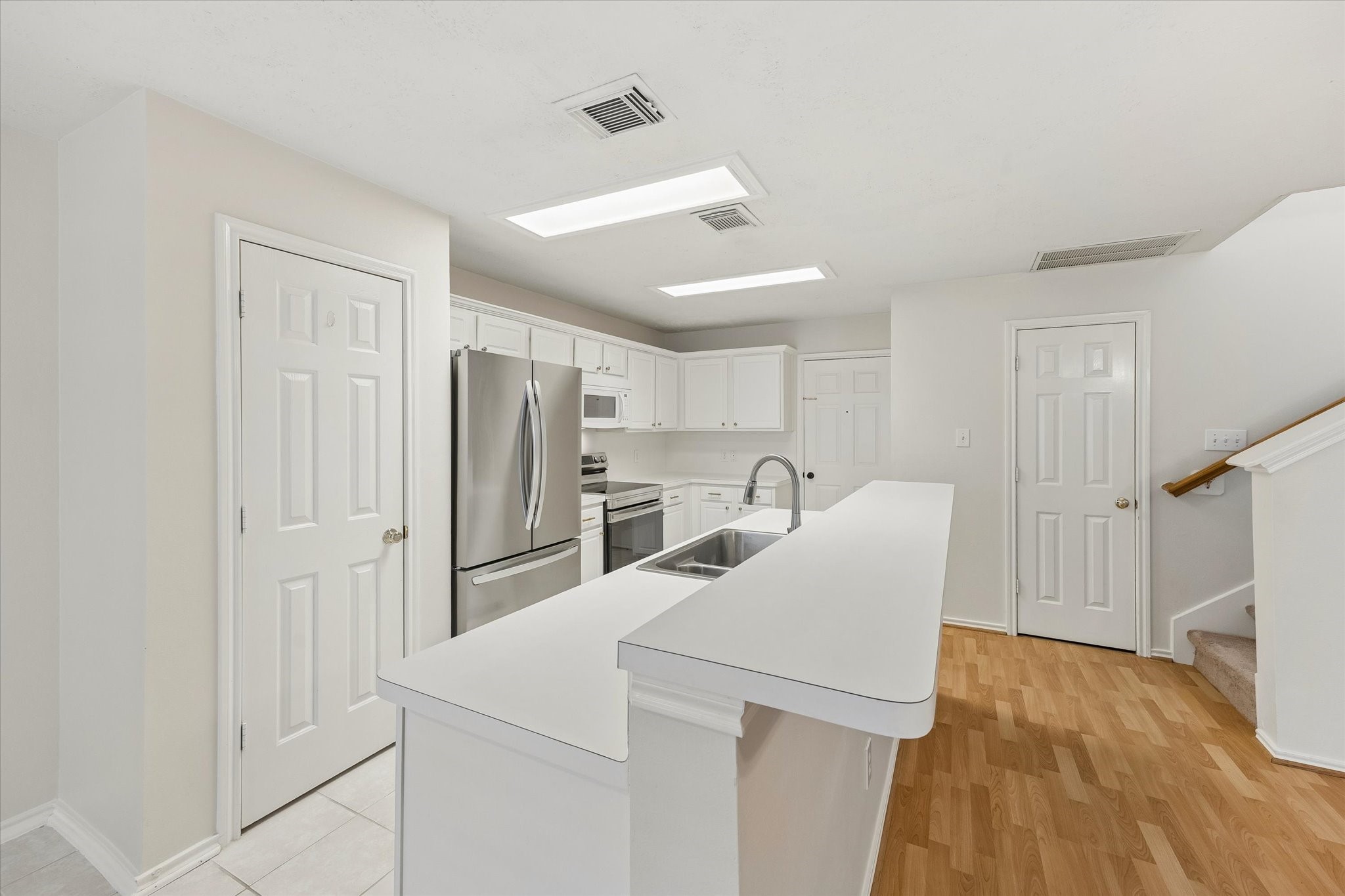 kitchen features a pantry, stainless steel refrigerator and oven, breakfast bar and dishwasher.