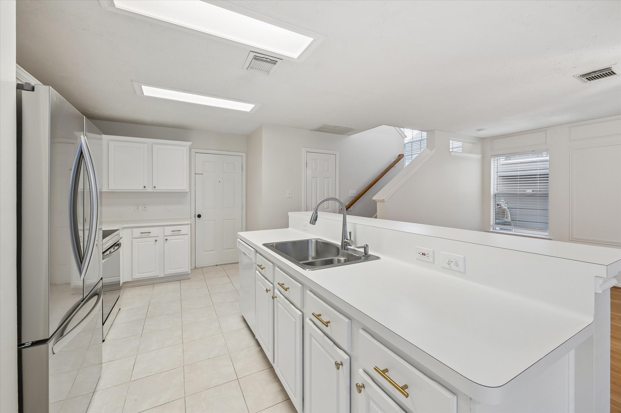 Tons of counter space! Easily bring groceries in from the garage. Powder room is door to right by the stairs.