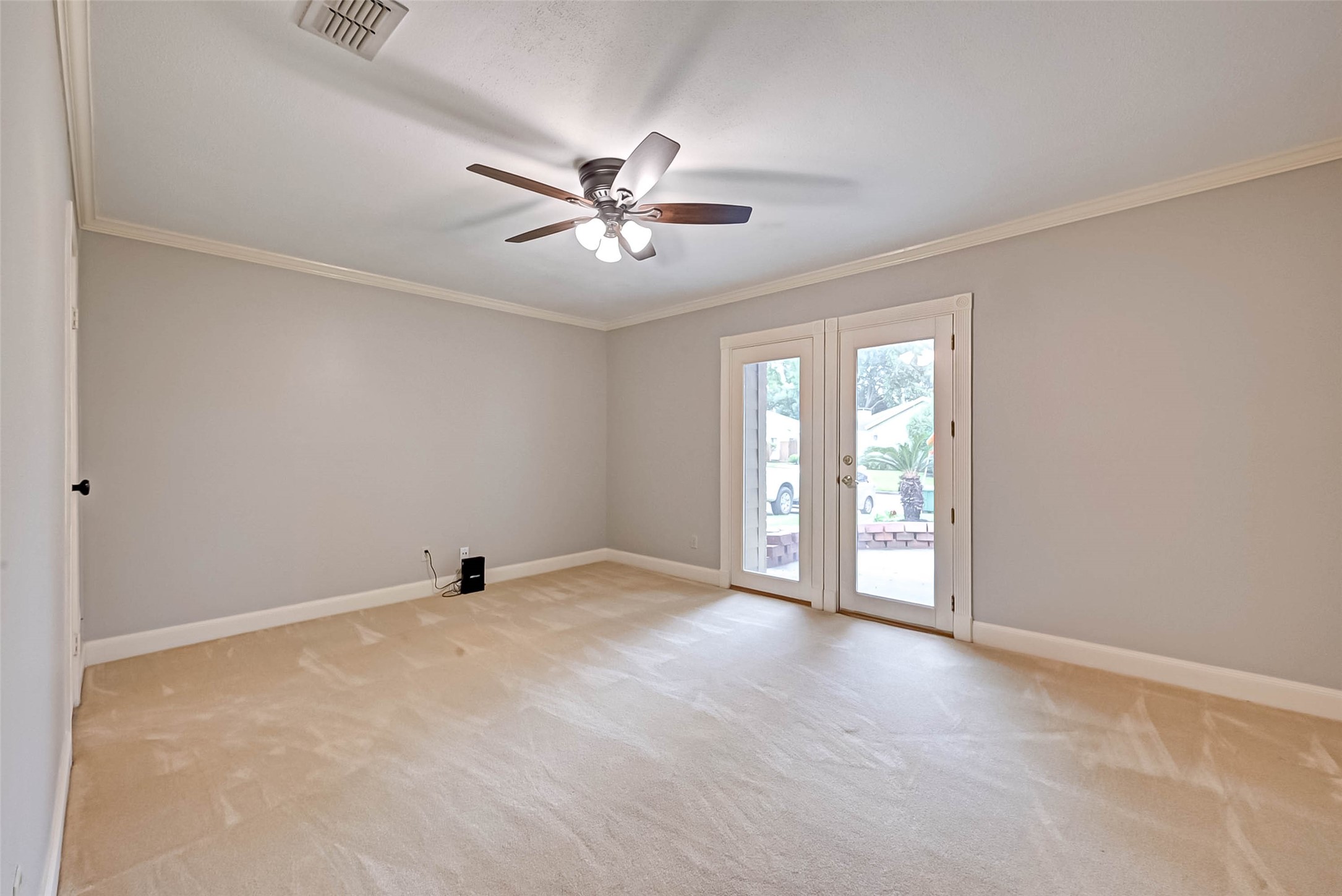 One guest bedroom with french doors leading to the outside.
