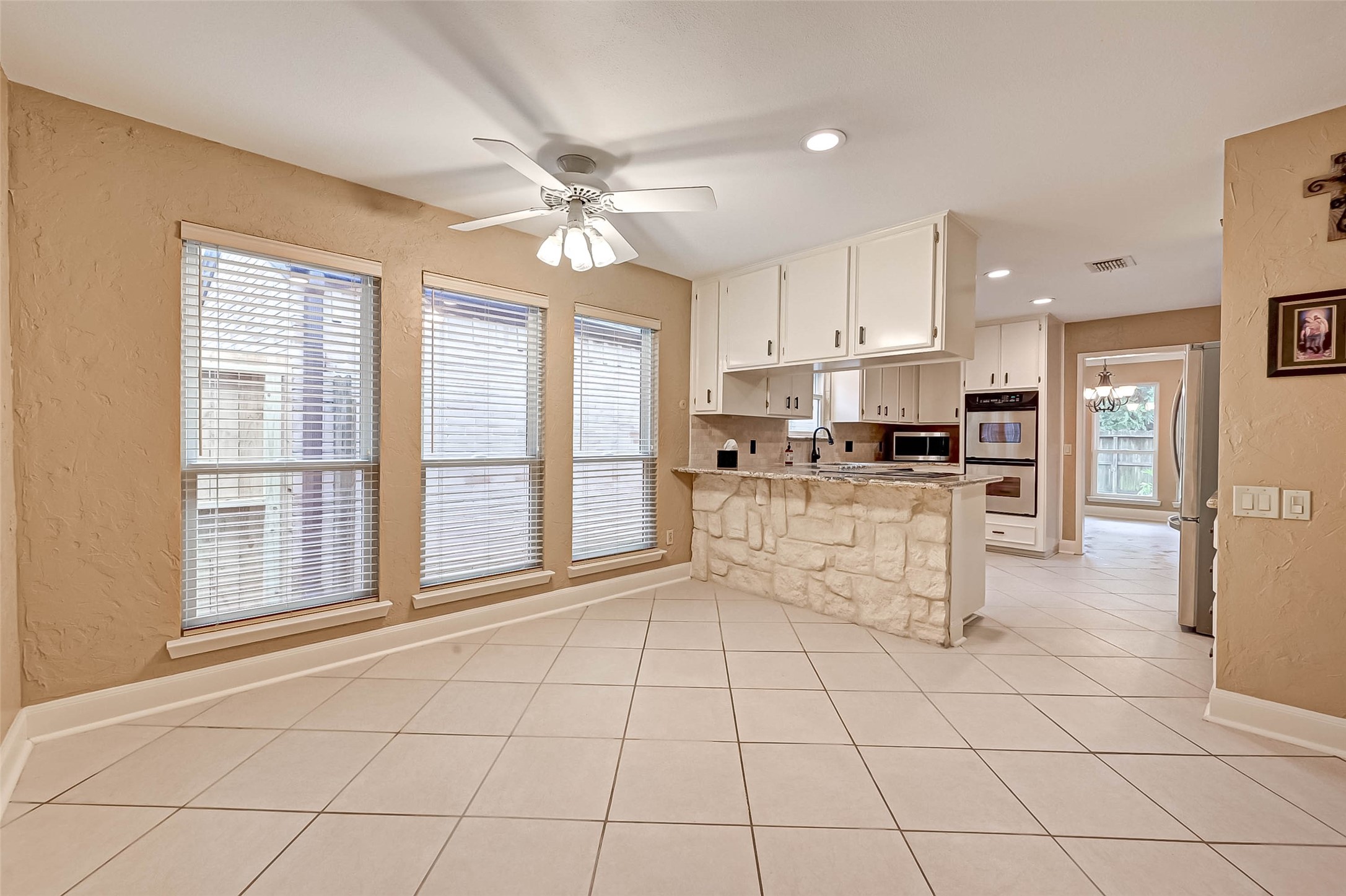 View of the lovely kitchen with stone accents as taken from the breakfast area.